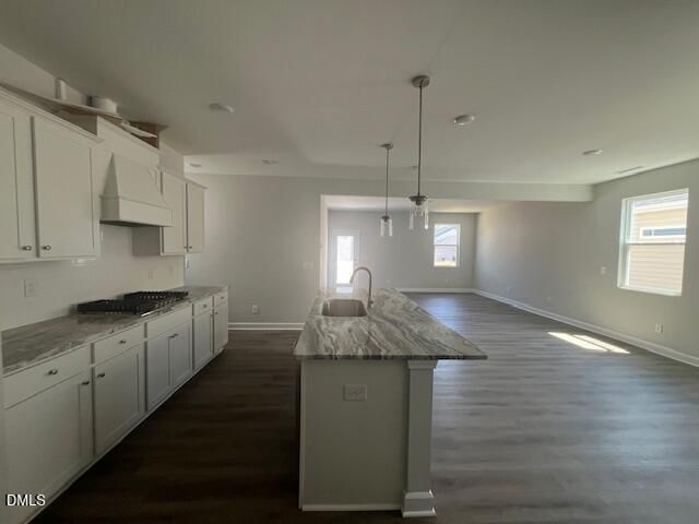 Modern kitchen with white shaker cabinets, veined granite island sink, and open layout in The Adalynn A by Davidson Homes, Lillington NC