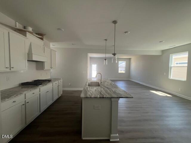 Modern kitchen with white shaker cabinets, veined granite island sink, and open layout in The Adalynn A by Davidson Homes, Lillington NC