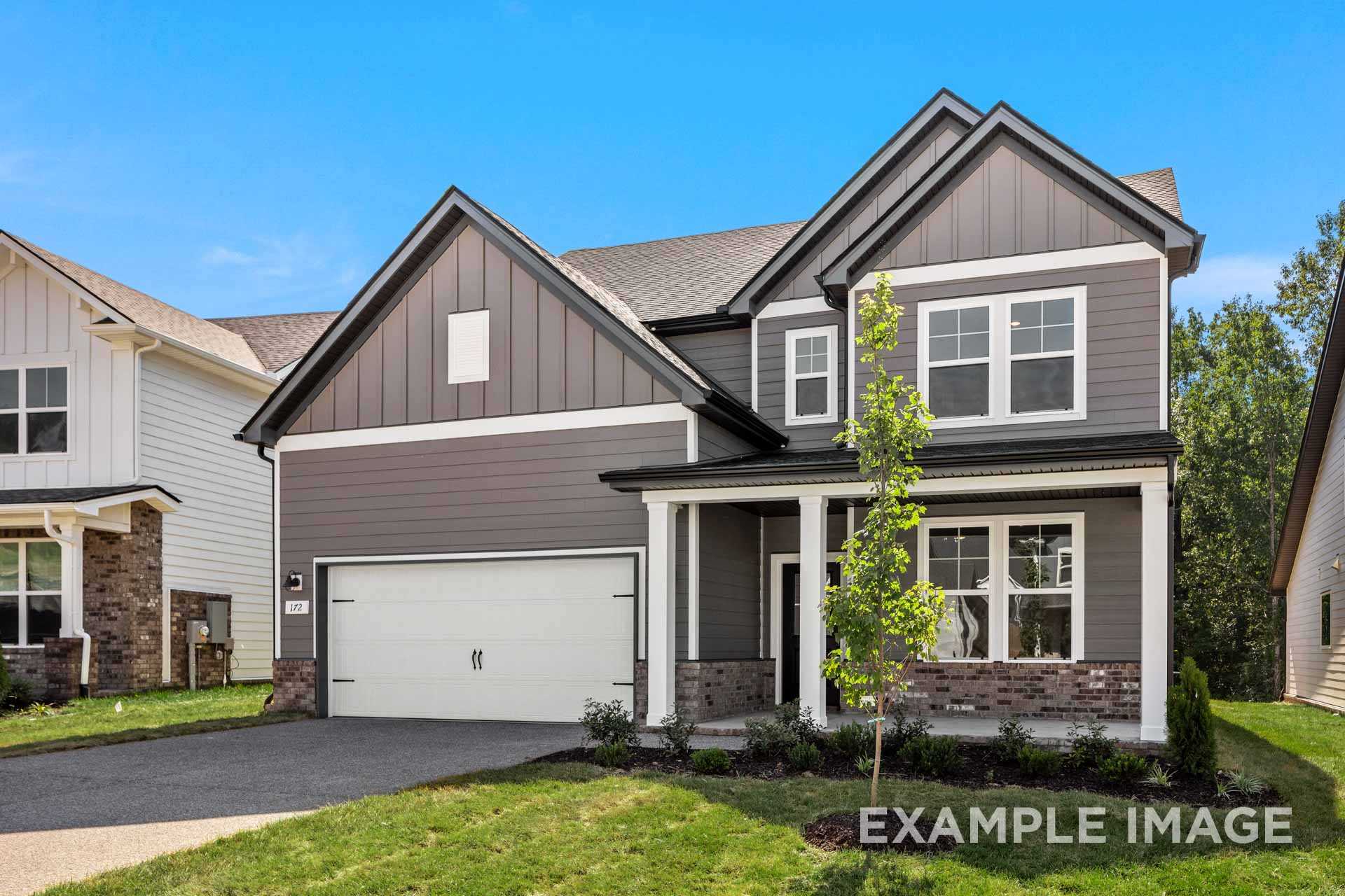 Modern two-story The Henry B home elevation featuring gray siding, covered front porch, two-car garage, and lush landscaping in Mt. Juliet