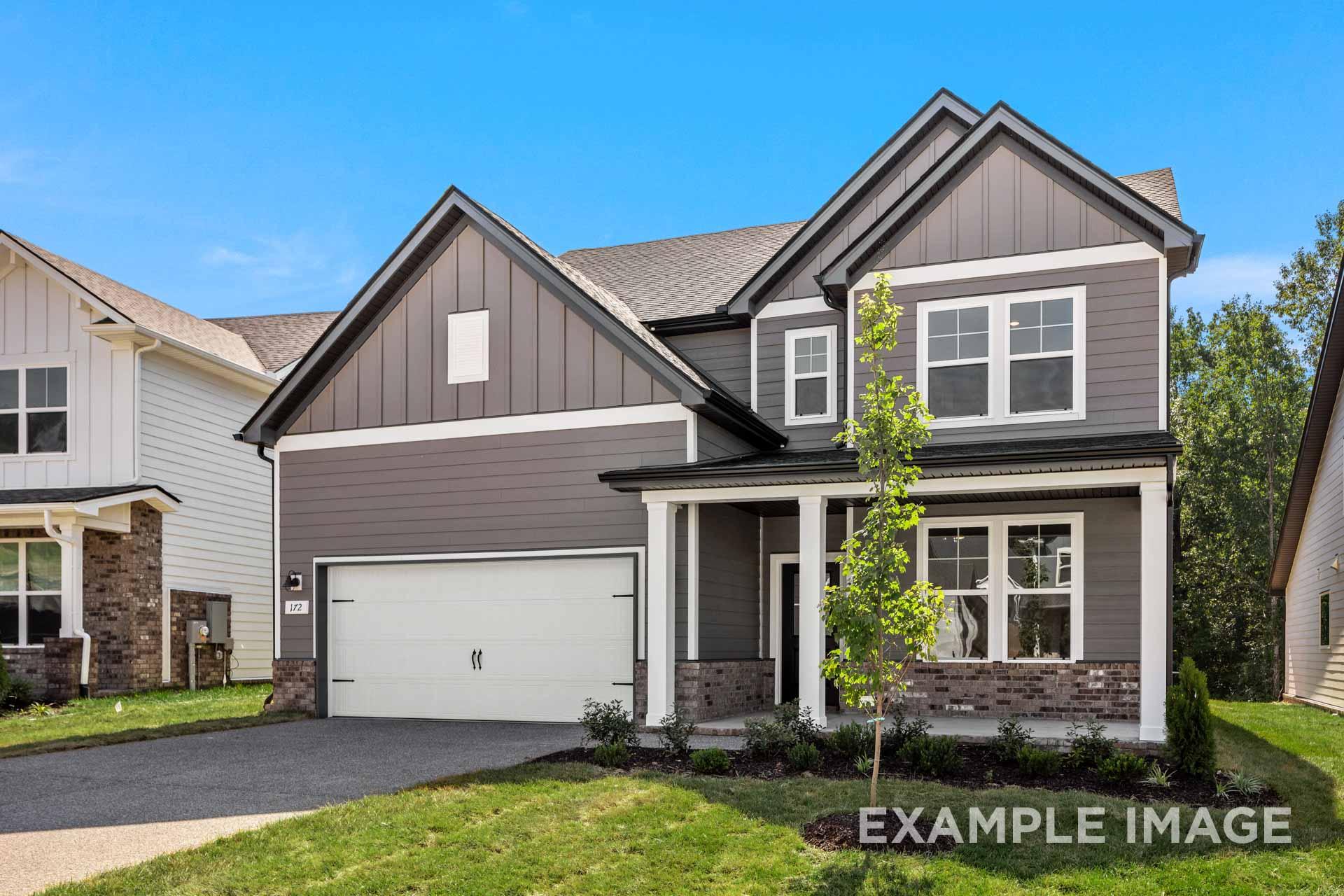 Modern two-story The Henry B home elevation featuring gray siding, covered front porch, two-car garage, and lush landscaping in Mt. Juliet