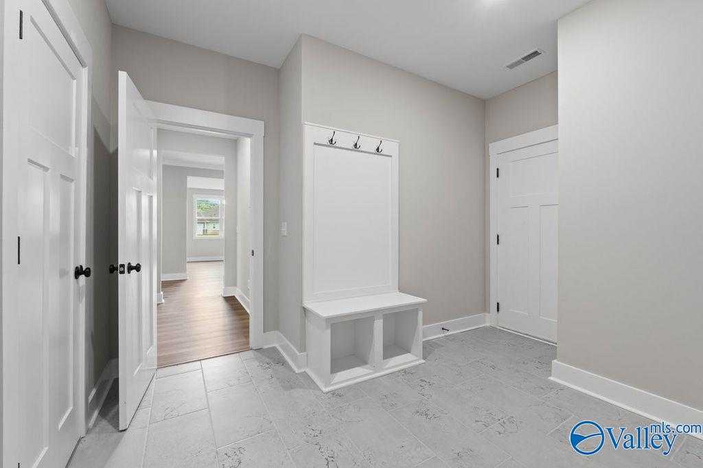 Functional mudroom with built-in bench, coat hooks, and storage in Evermore Homes The Oxford, Owens Cross Roads, Alabama
