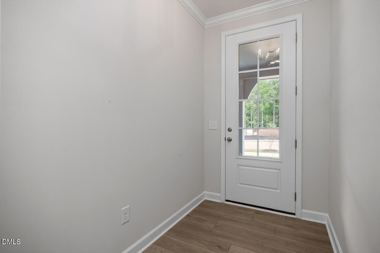 White glass-paneled entry door with hardwood flooring in The Ashport G floor plan at Sage on North Main, Wake Forest, NC.