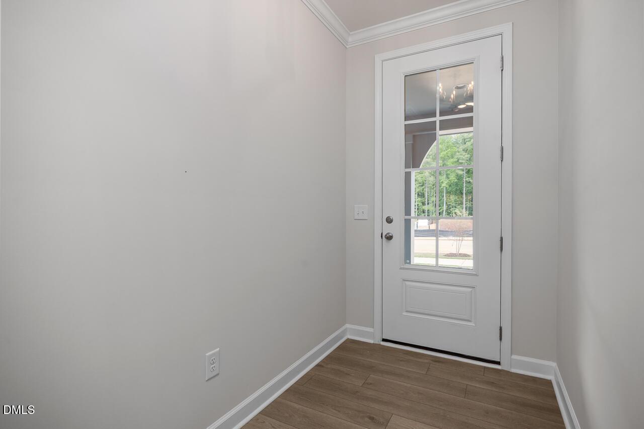 White glass-paneled entry door with hardwood flooring in The Ashport G floor plan at Sage on North Main, Wake Forest, NC.