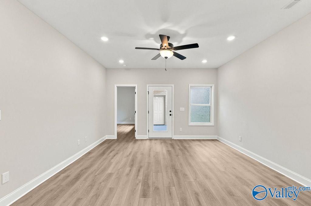 Bright living room with LVP flooring and ceiling fan in The Camilla C floor plan at The Retreat at Cain Park, Hartselle.