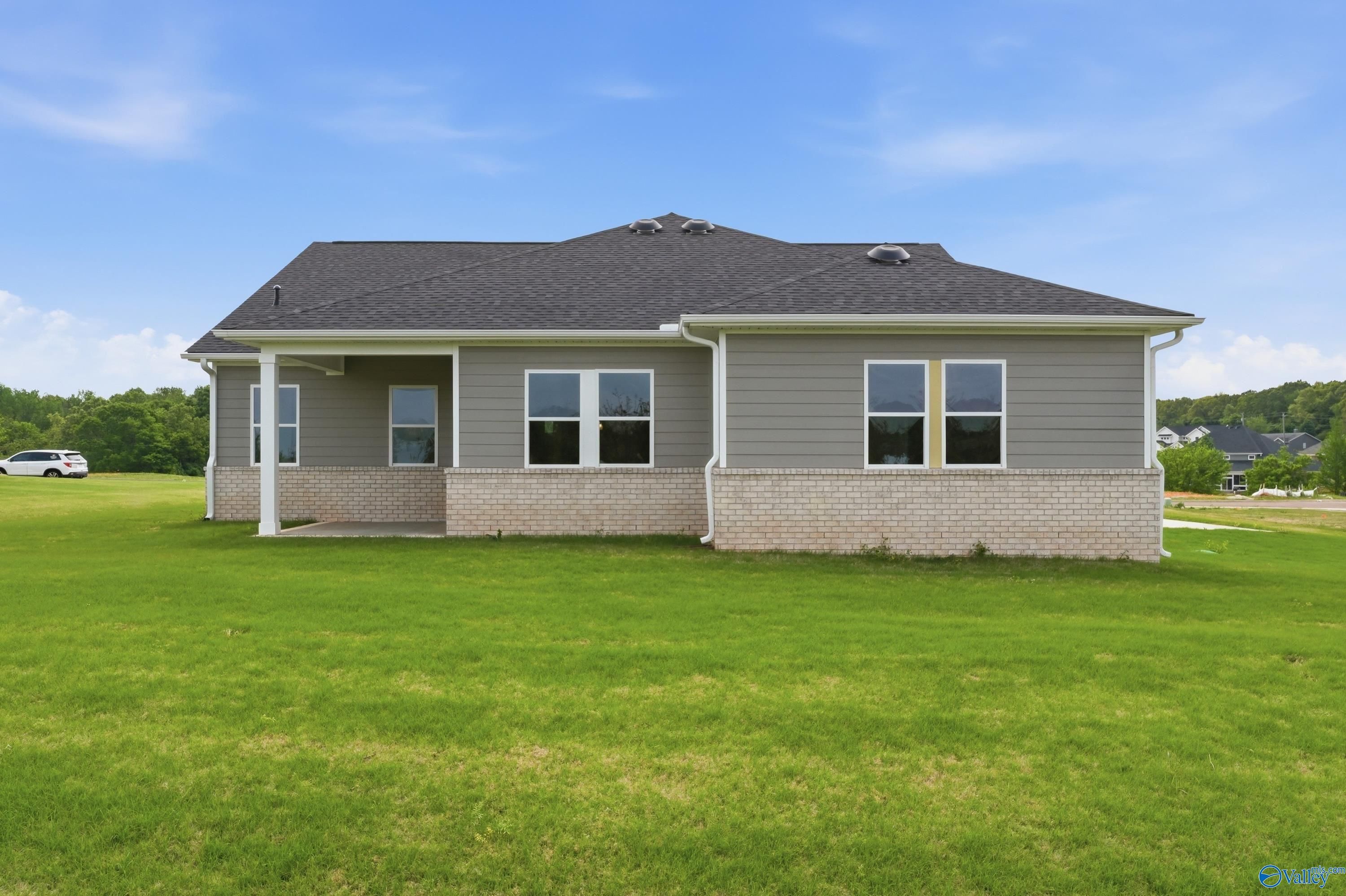 Gray-sided single-story Arcadia B home with brick base, covered porch, and lush lawn in Riverton Preserve, Huntsville, AL