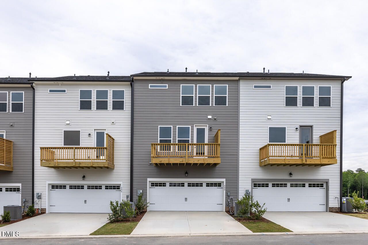 Exterior of 3-story townhomes with 2-car garages and balconies at Forestville Yard in Knightdale, North Carolina.
