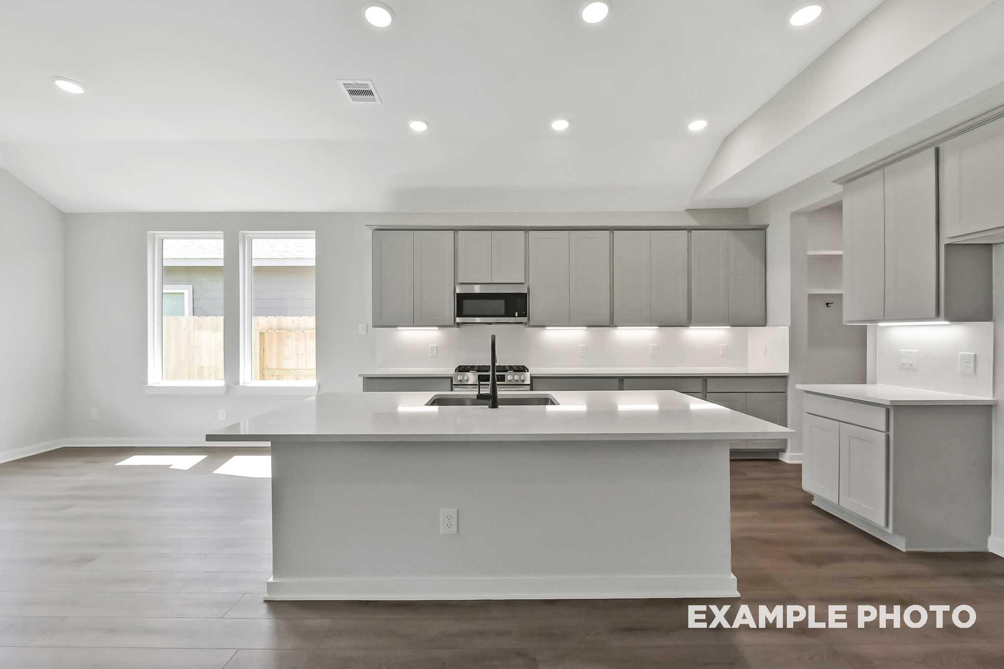Modern Sequoia kitchen by Davidson Homes with gray cabinets, white quartz island, sink, and open layout