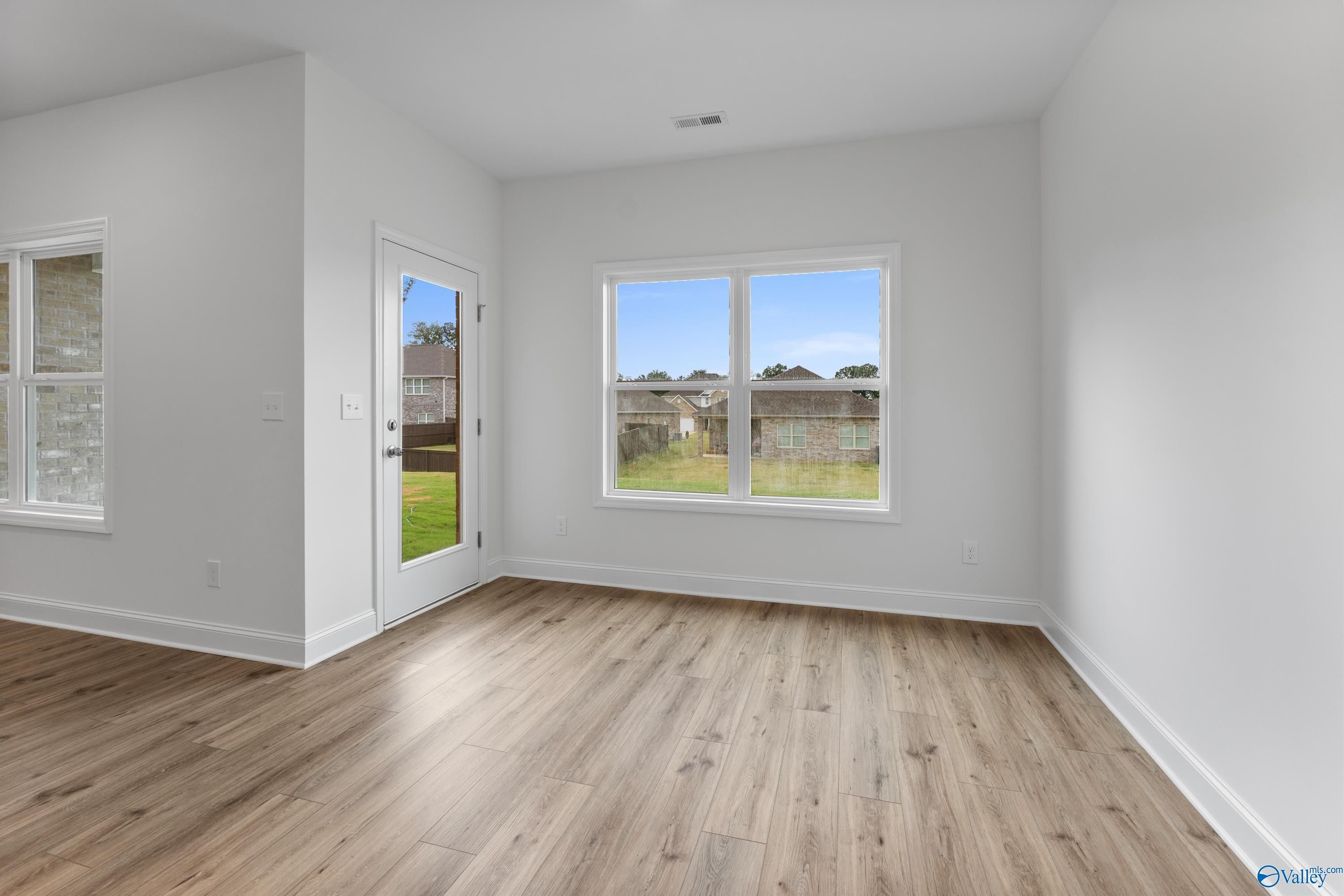 Bright sunroom with hardwood floors, French doors, and scenic backyard view in Davidson Homes The Asheville C, New Market, Alabama
