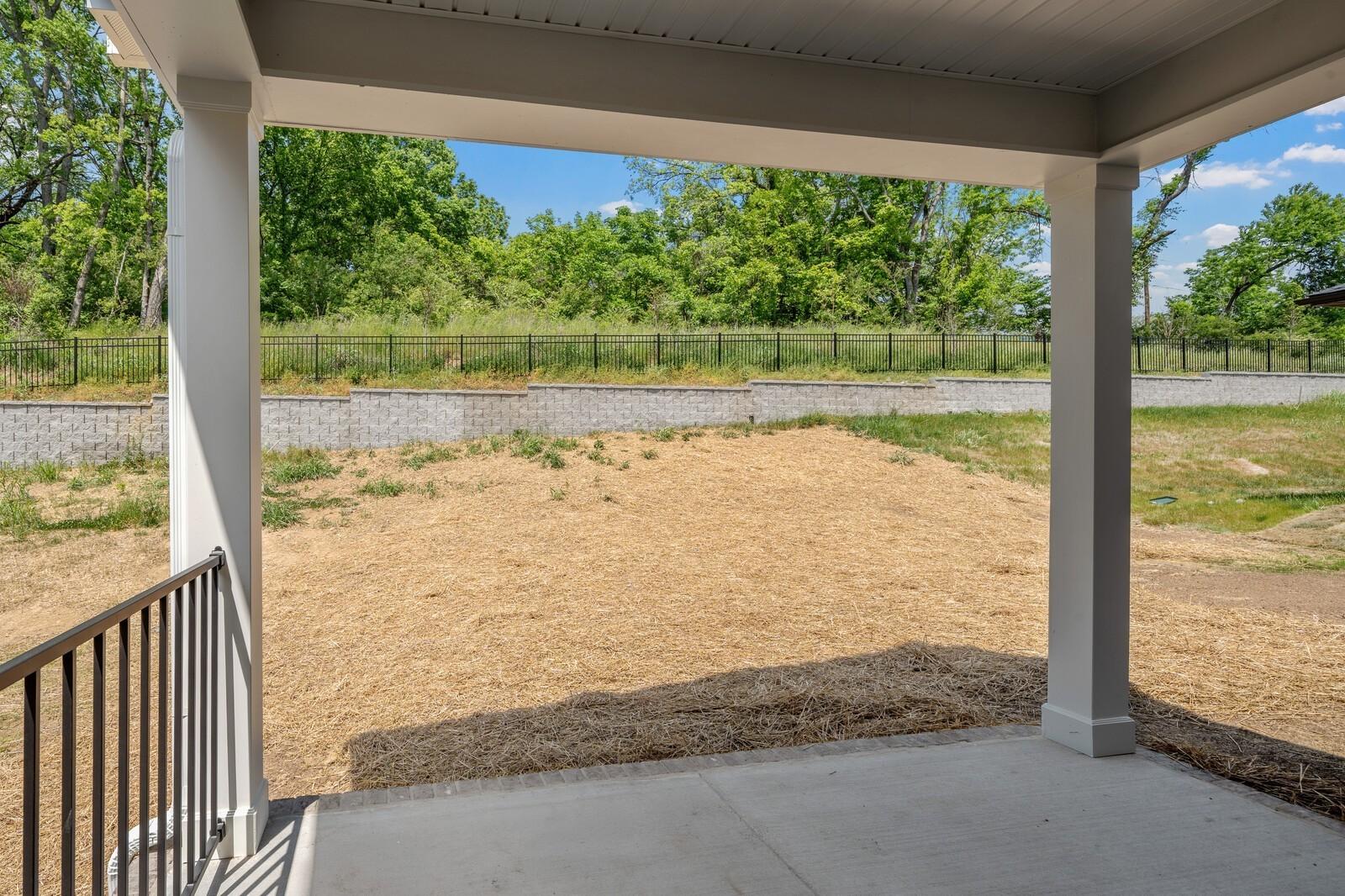 Covered back patio looking out to a private fenced backyard at The Willow in Woods Crossing, Gallatin, Tennessee.