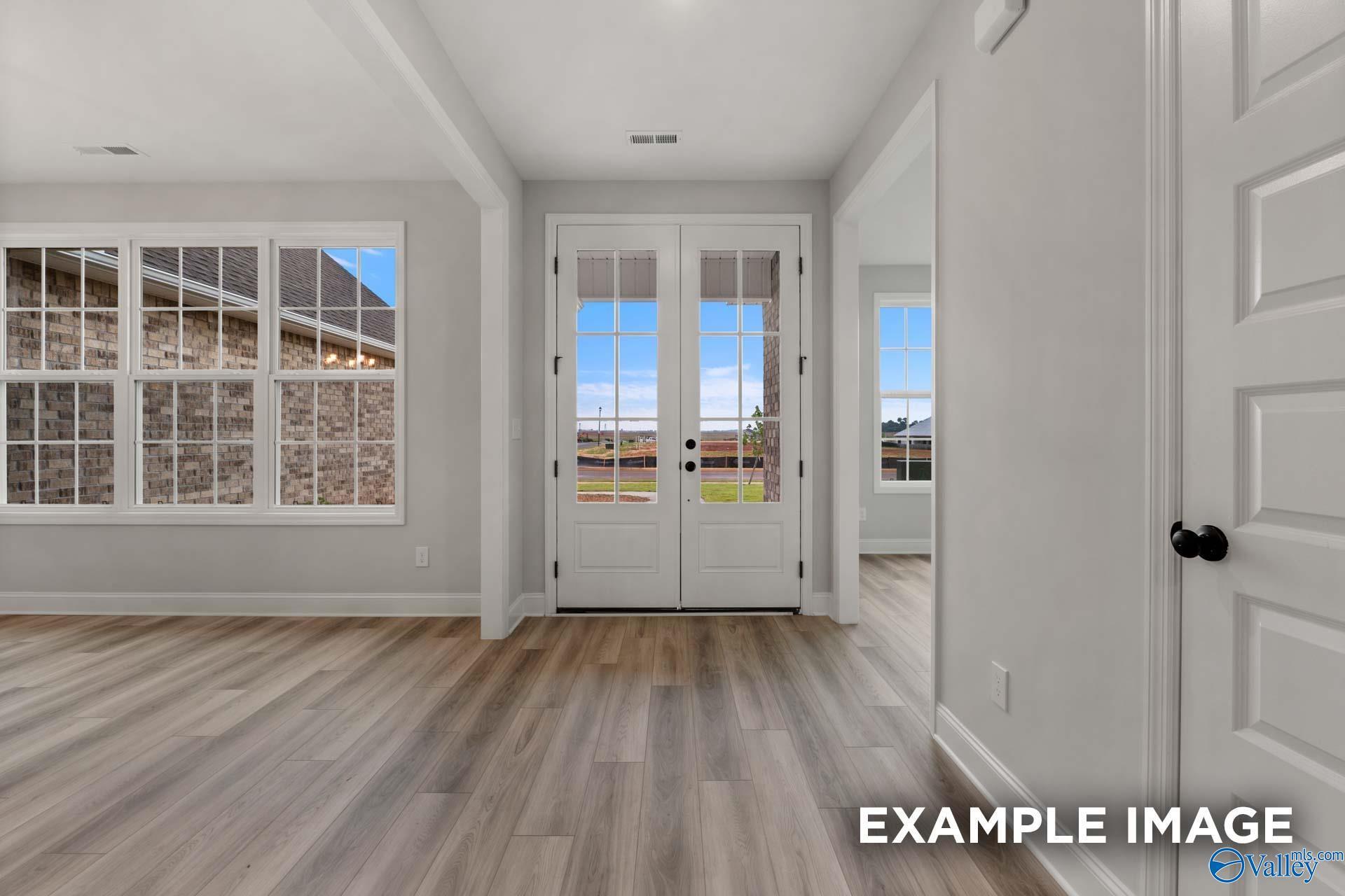 Bright hallway with French doors to backyard patio and large windows in Davidson Homes The Finleigh, Meridianville, Alabama