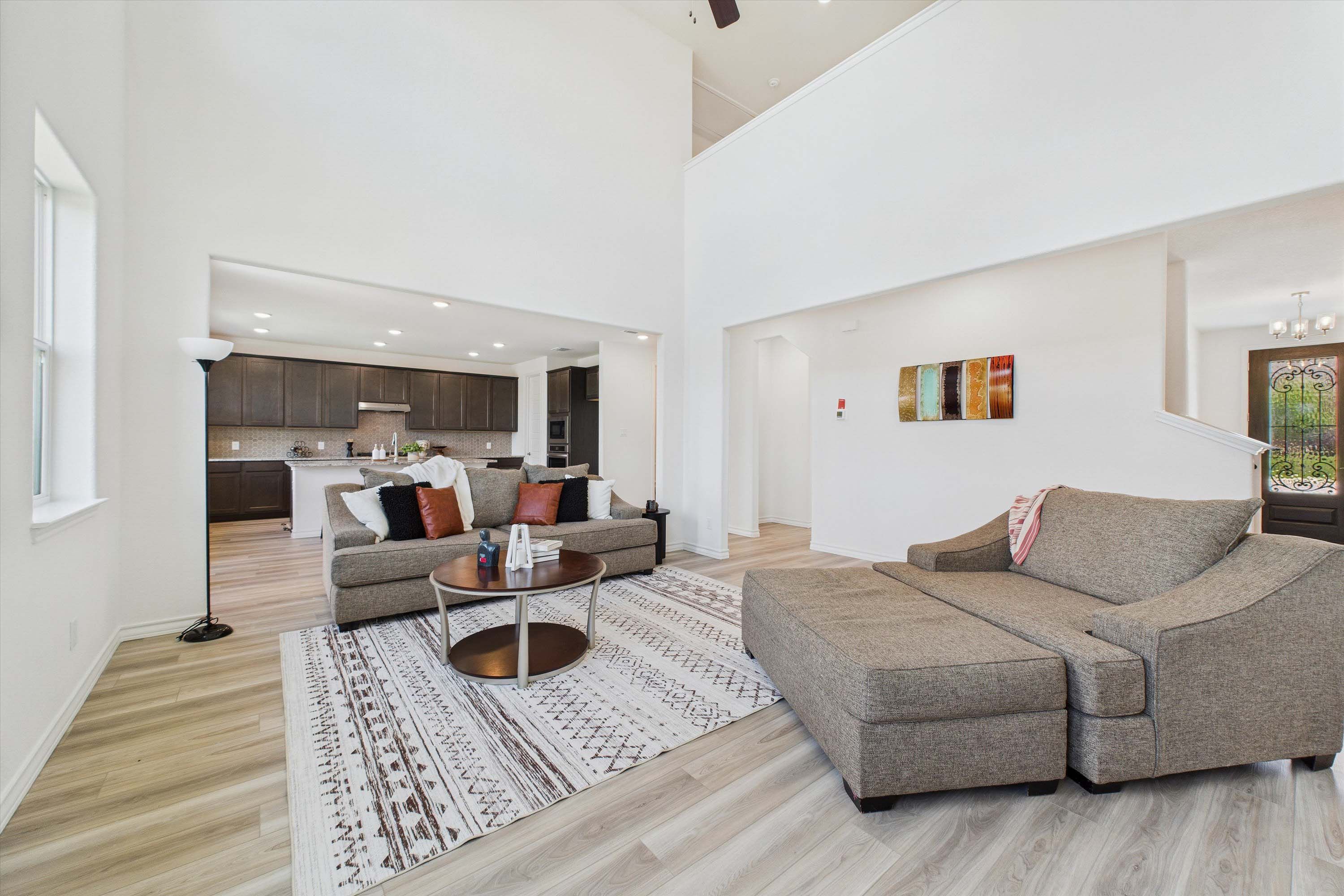 Spacious two-story living area in The Danbury by Davidson Homes featuring open-concept design and view of kitchen.