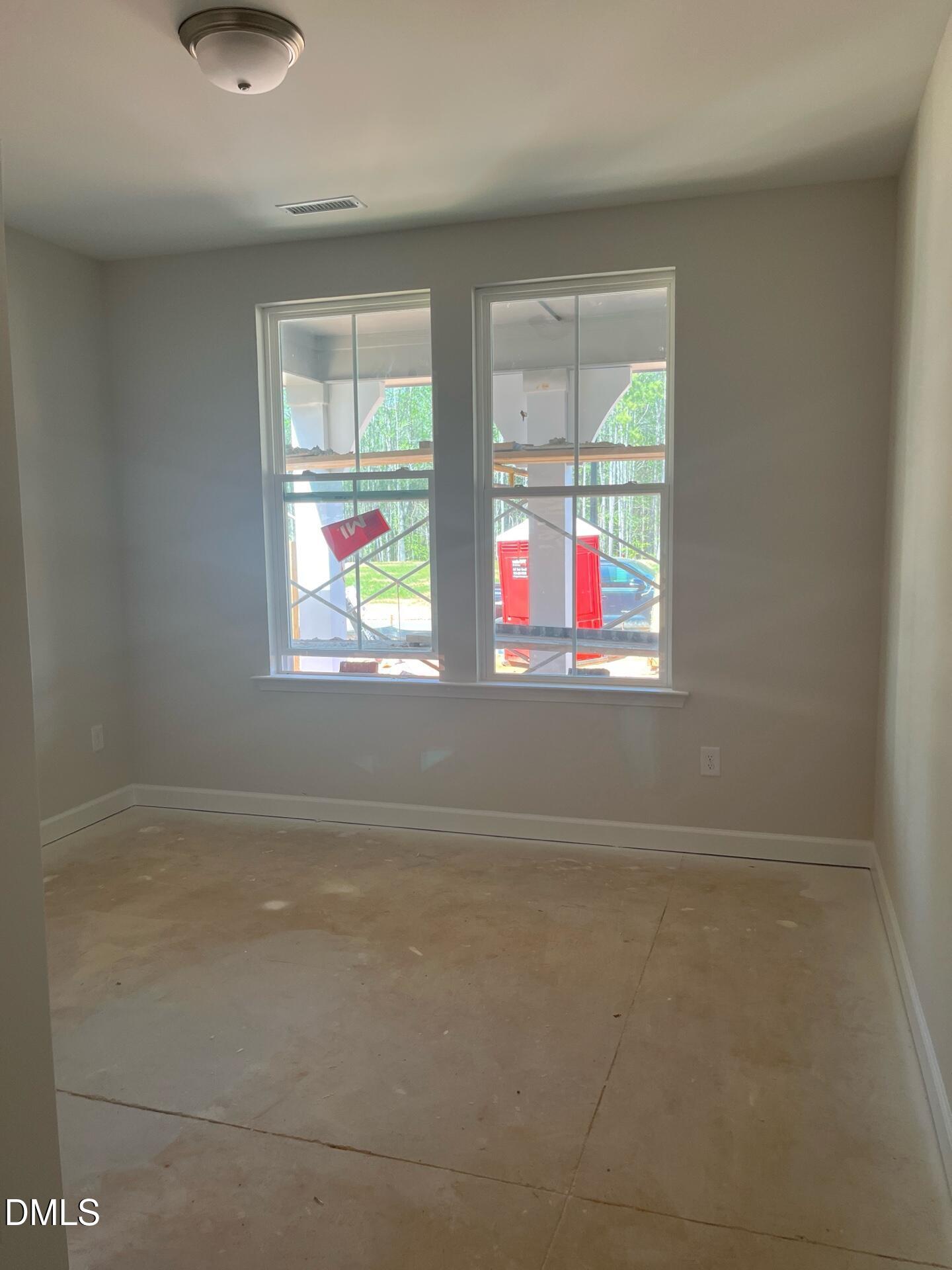 Bright secondary bedroom with large windows, neutral walls, and unfinished flooring in Davidson Homes Ashport G, Wake Forest, NC