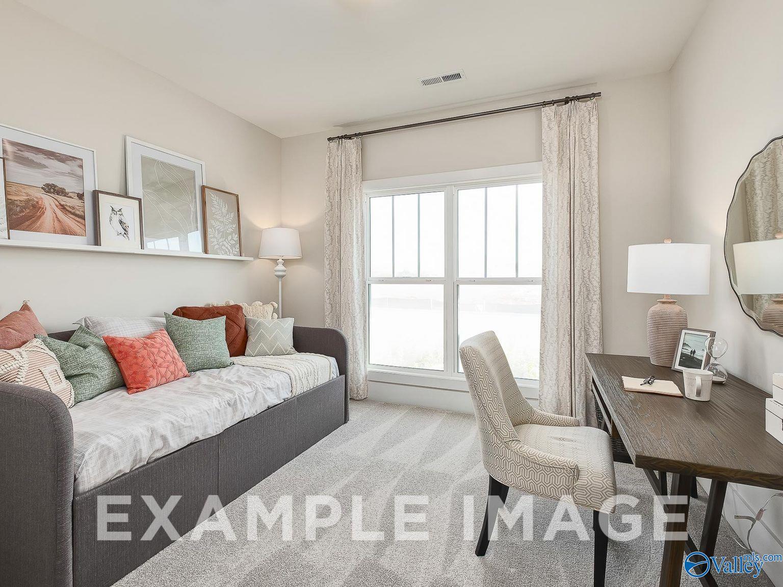 Cozy bedroom with gray daybed, wooden desk, and large windows in Davidson Homes Everett B, Ivy Hills Toney AL