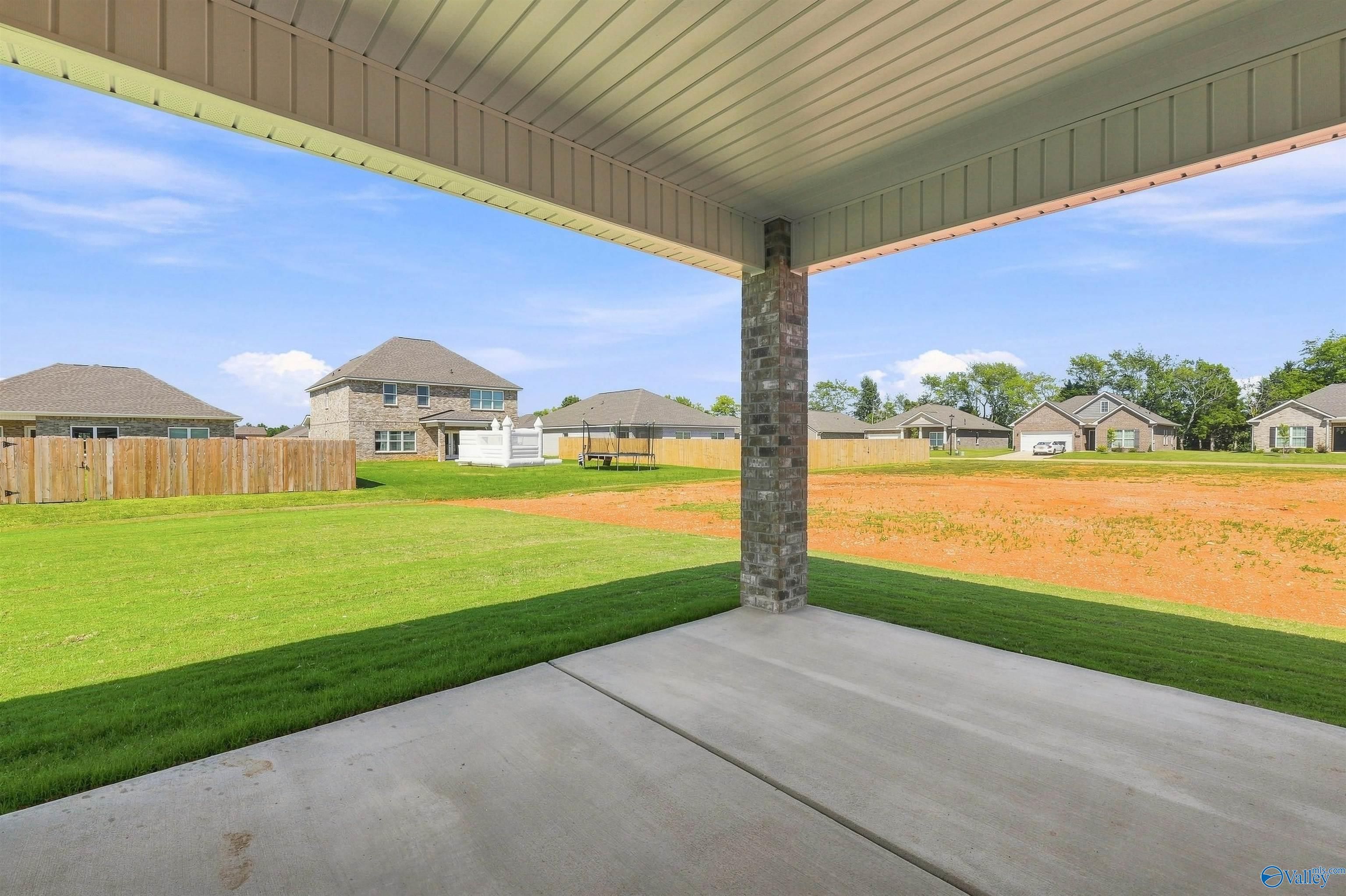 Covered patio with brick column overlooking spacious backyard and neighboring homes in Davidson Homes Everett B plan, Ivy Hills, Toney, Alabama