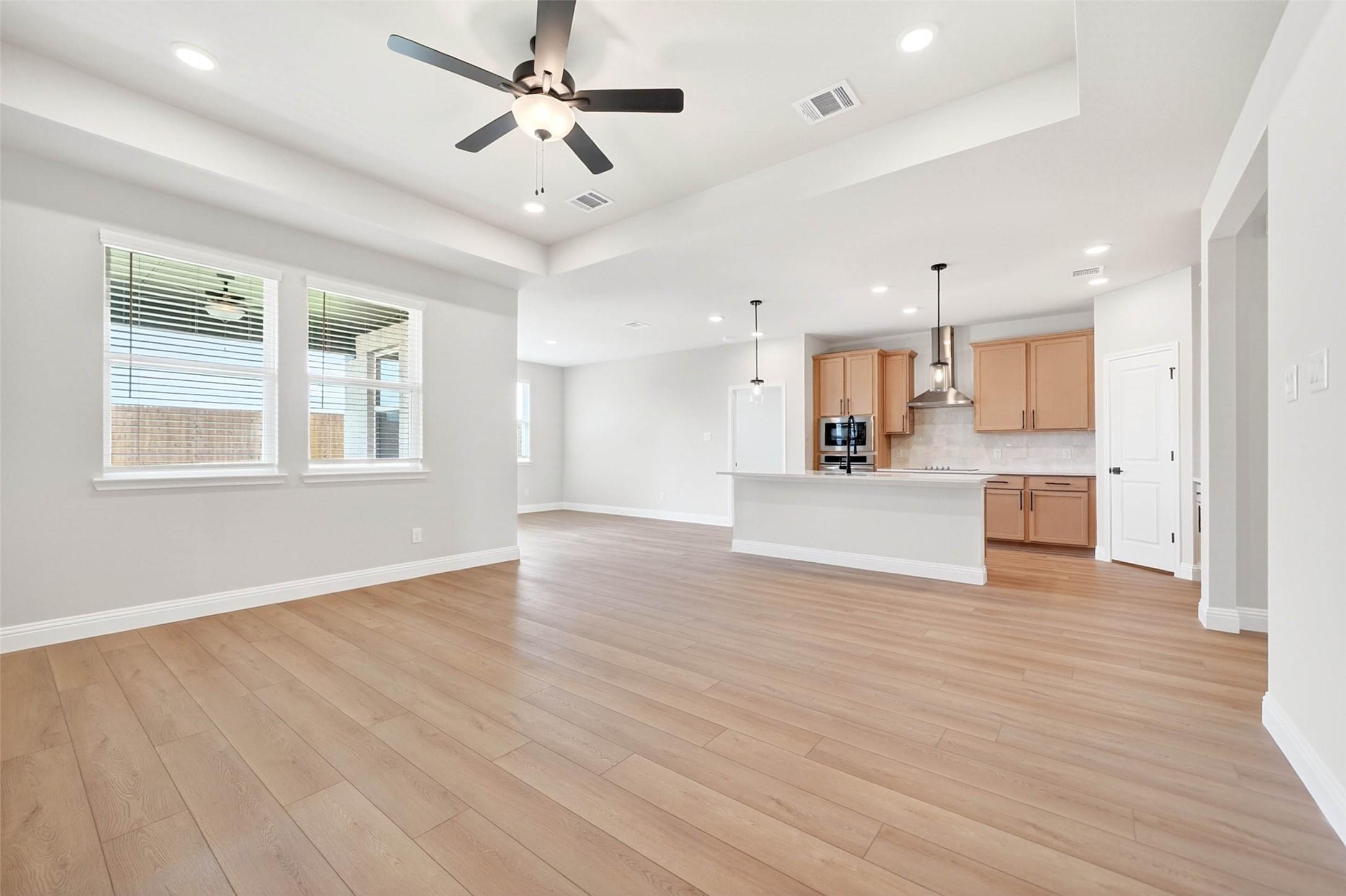 Open-concept living room and kitchen in The Holly C floor plan by Davidson Homes in Parks at Foster Crossing, Anna, Texas.