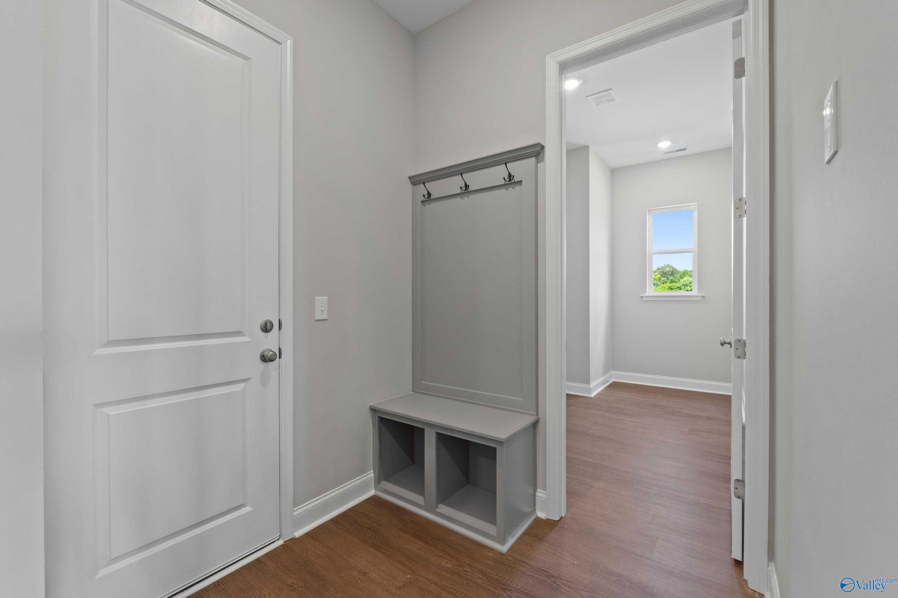 Functional mudroom with built-in bench, coat hooks, and hardwood floors in Davidson Homes The Arcadia, Riverton Preserve, Huntsville AL