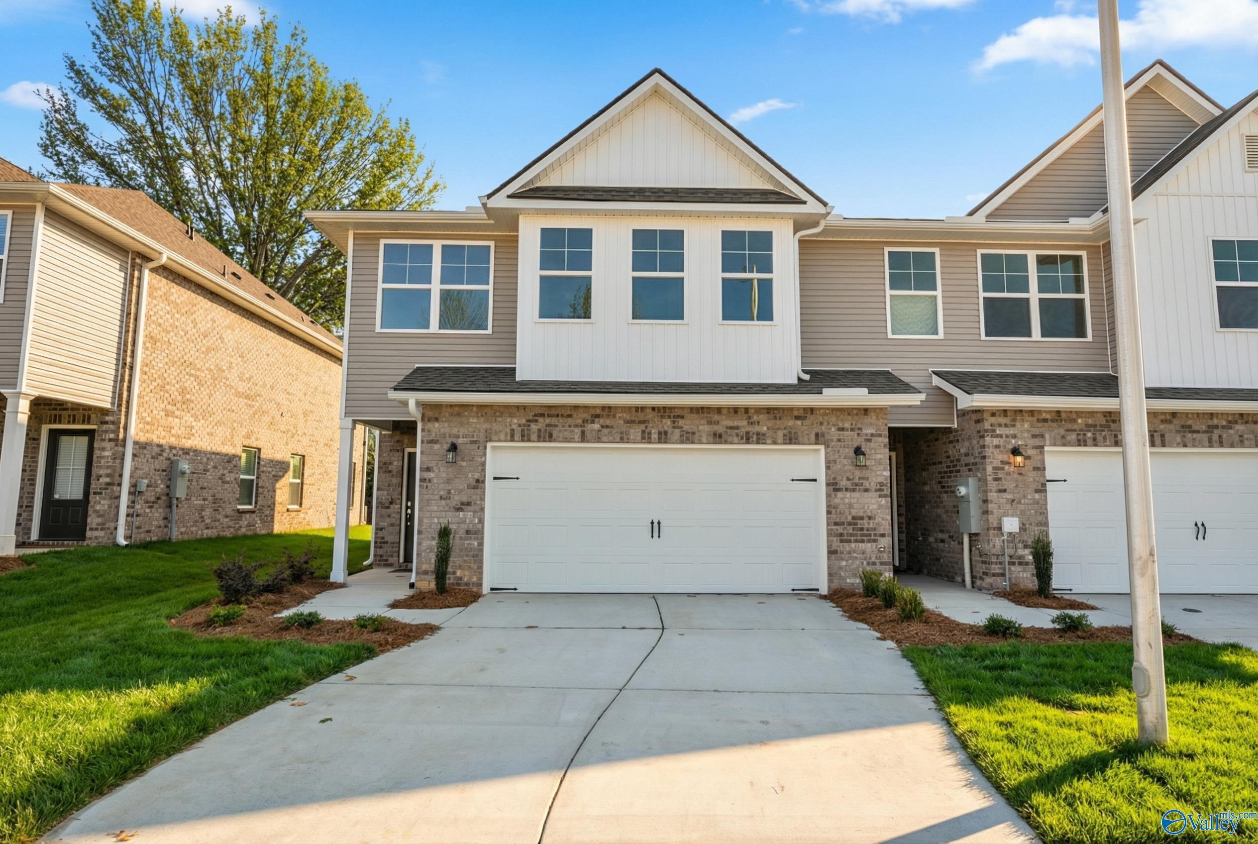 Modern two-story Camden home exterior with two-car garage, driveway, and landscaped yard in Pavilion, Huntsville, Alabama