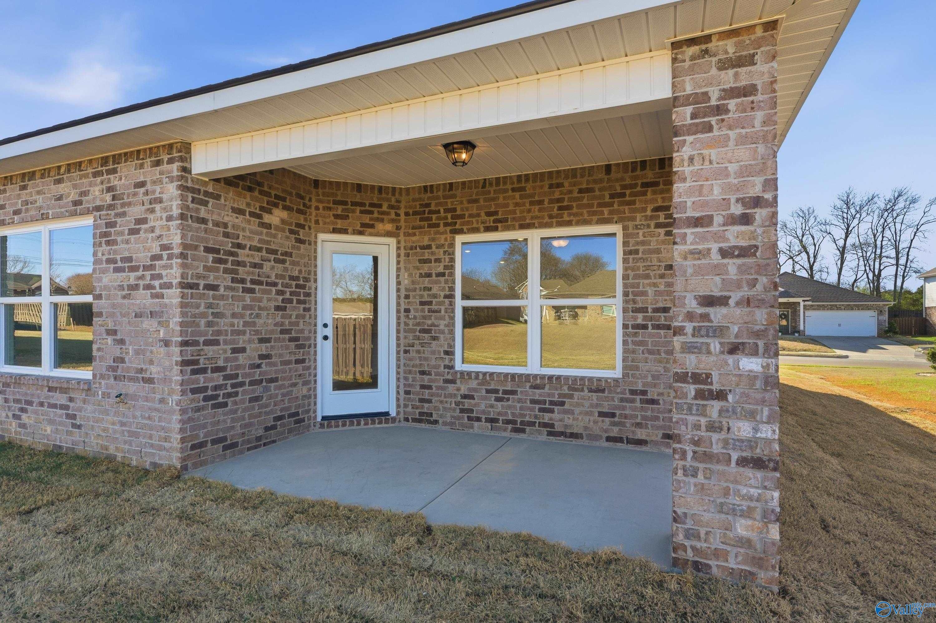 Brick ranch exterior with covered porch, white door, and large windows in Flint Meadows, New Market, Alabama - Davidson Homes Franklin C