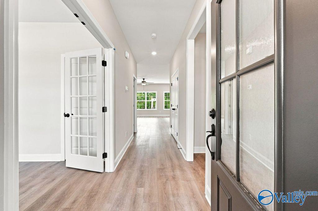 Foyer with glass-paneled front door, French door, and hardwood floors in Davidson Homes Rockford plan, Hartselle, Alabama