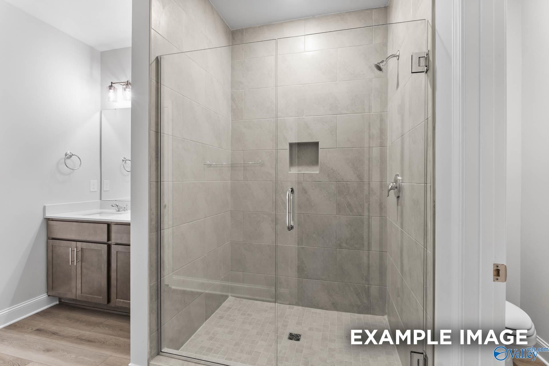 Modern master bathroom featuring frameless glass shower, subway tile, and double vanity in Davidson Homes The Daphne C, Arab, Alabama