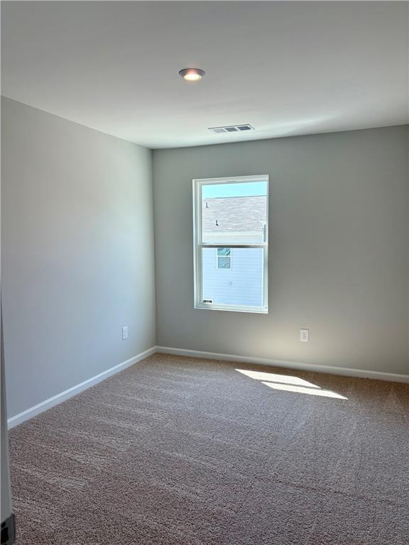 Bright secondary bedroom with light gray walls, beige carpet flooring, and sunlit window in Davidson Homes The Monroe B, Emerson, GA