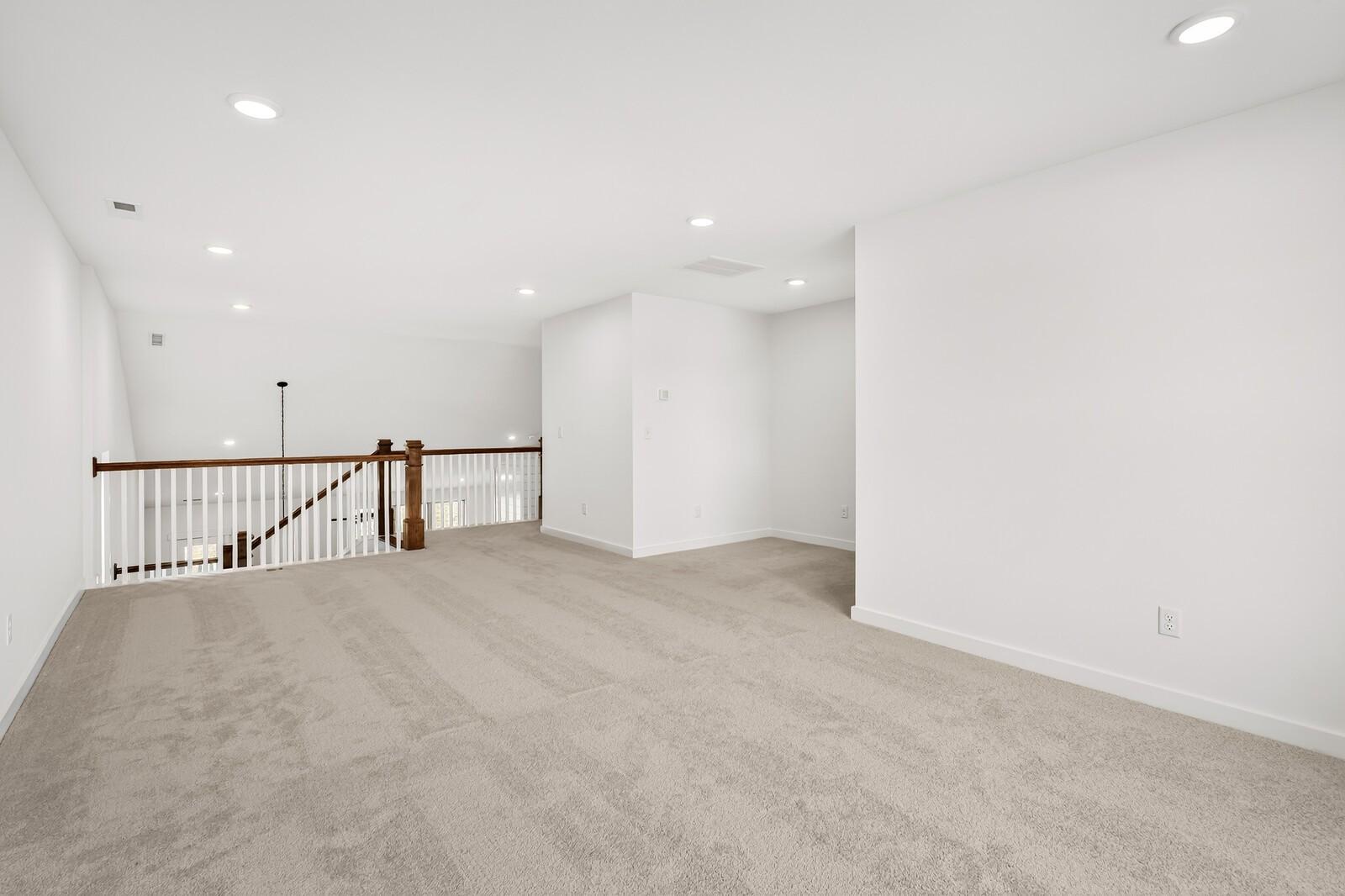 Bright upstairs loft with beige carpet, white walls, recessed lights, and wooden balustrade in 5-bed Ridgeport C home, Gallatin, TN