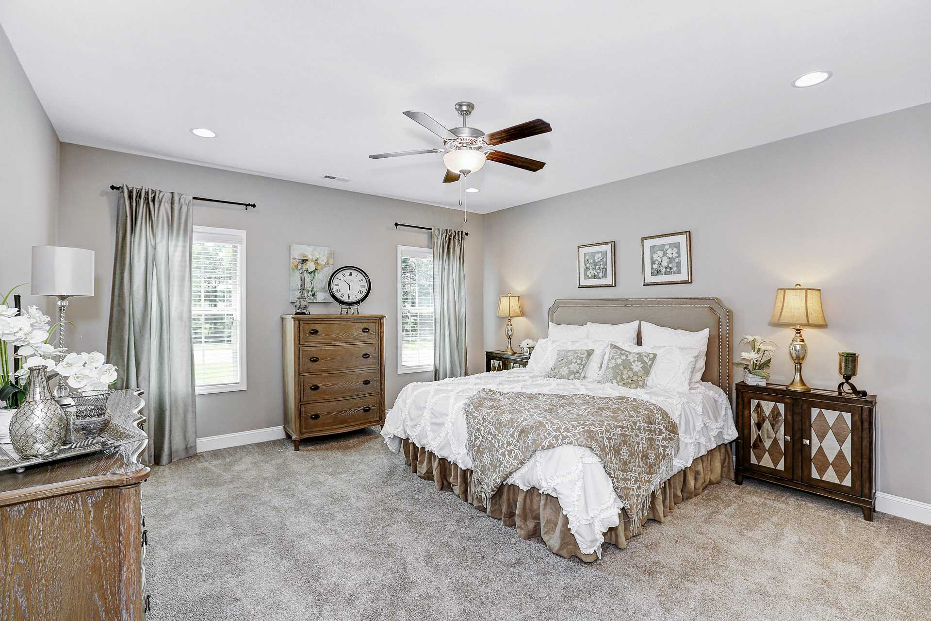 Spacious master bedroom in Stone Creek Phase II Cullman AL with king bed, ceiling fan, wooden dresser, and neutral tones