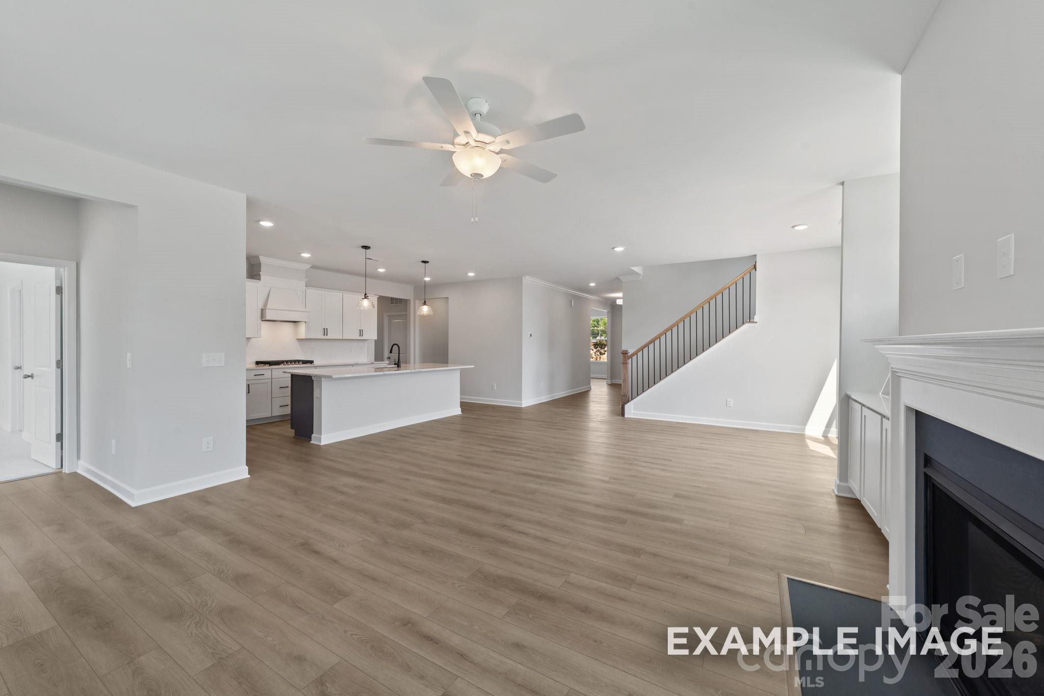 Open-concept floor plan with kitchen, living area, and staircase in The Magnolia B home by Davidson Homes in Mooresville, NC.