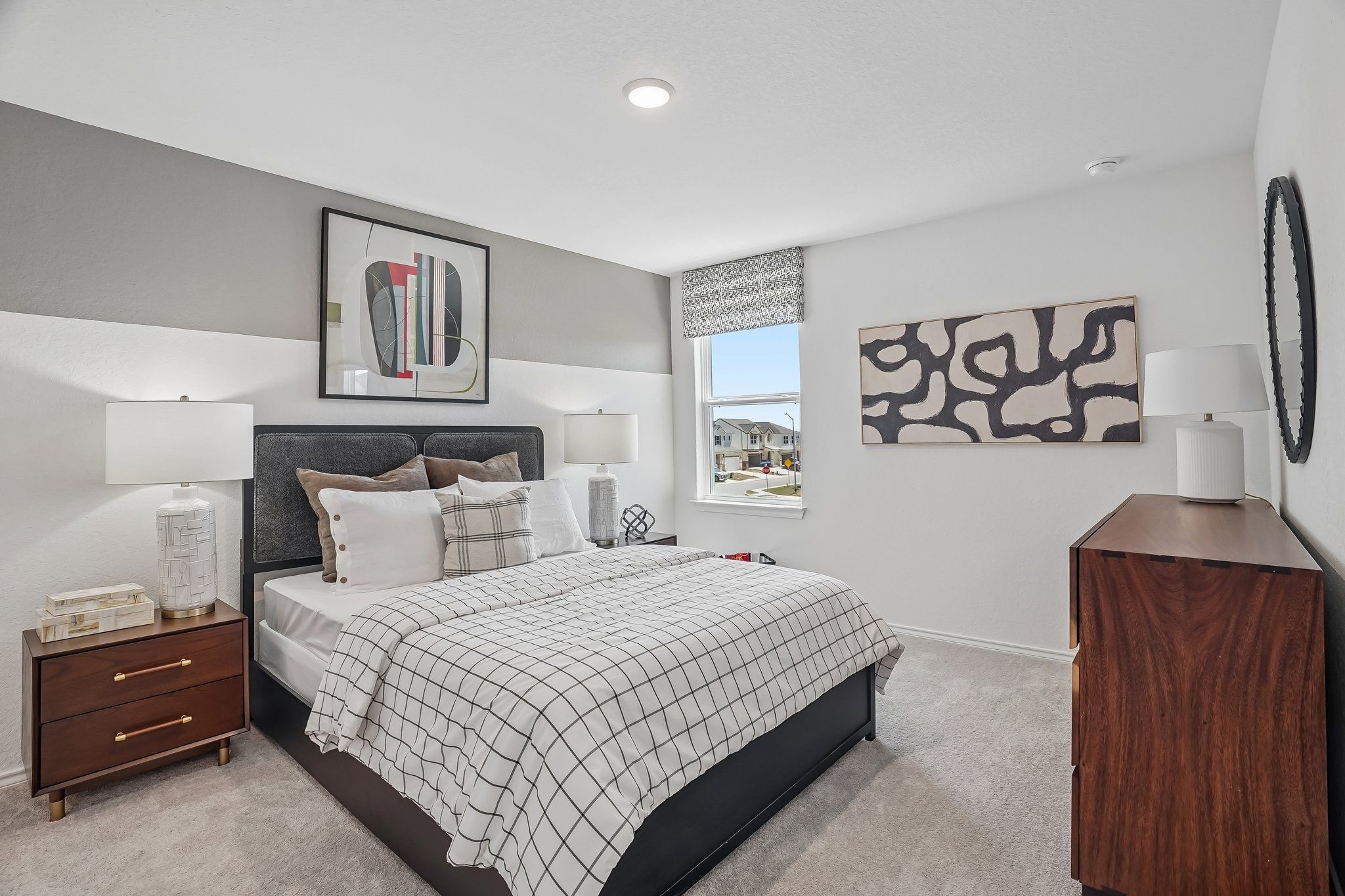 Modern bedroom in Fairway Crossing by Davidson Homes in Converse, Texas with king bed, mid-century furniture, and art.