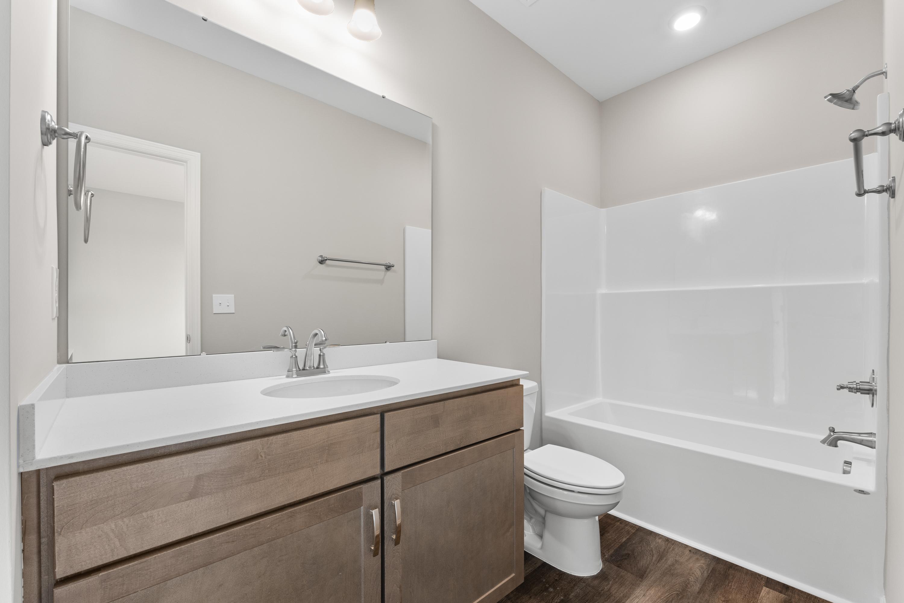 Modern master bathroom in The Haven E featuring quartz double vanity, soaking tub, walk-in shower, and neutral tones