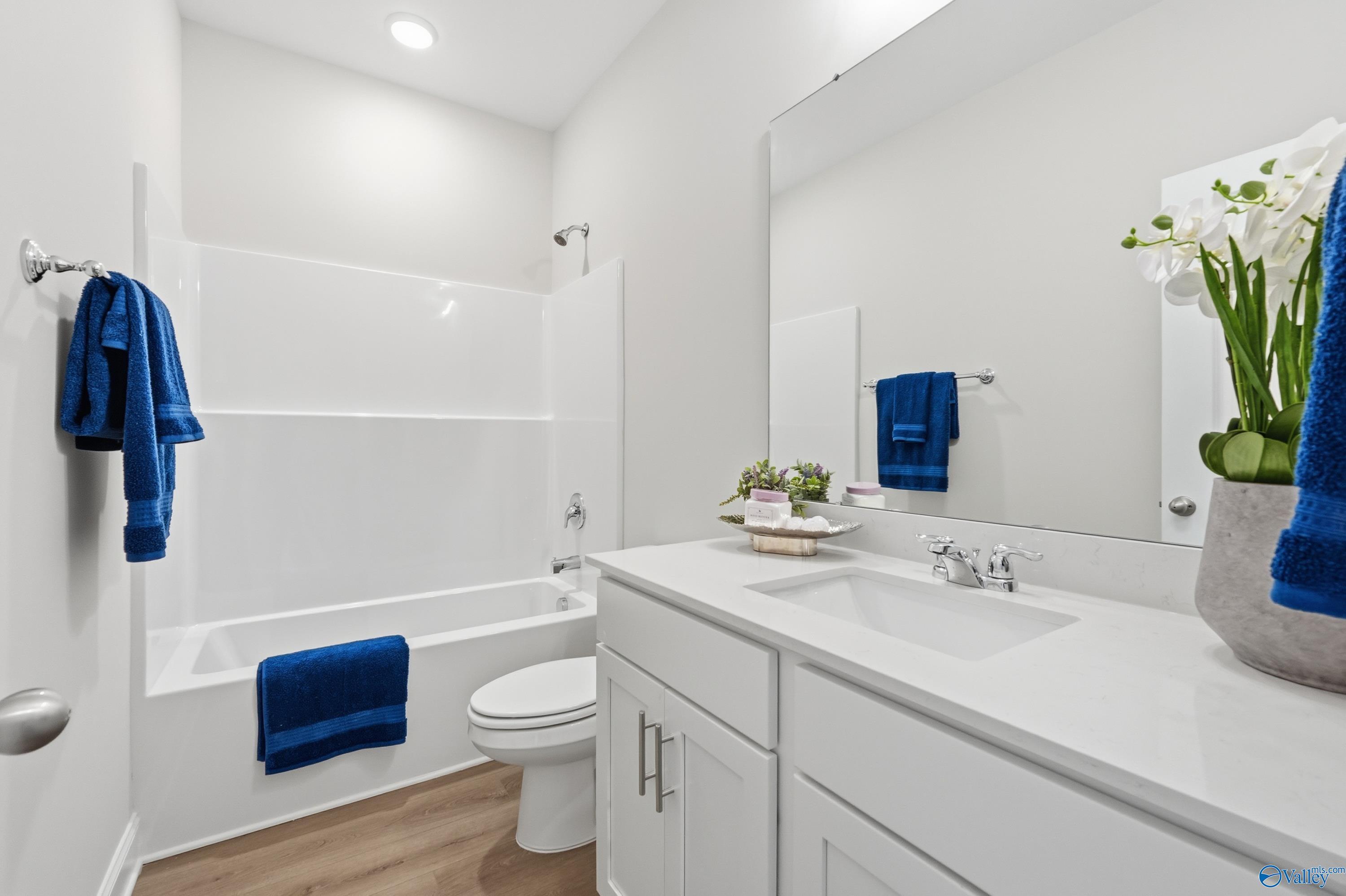 Modern bathroom with white subway tile tub-shower combo, single vanity, blue towels in Davidson Homes The Asheville, Toney, Alabama