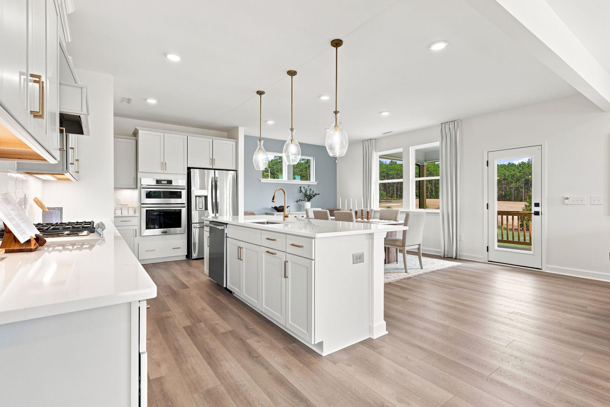 Modern kitchen with white cabinetry and center island at Montrose in Aberdeen, NC, built by Davidson Homes.