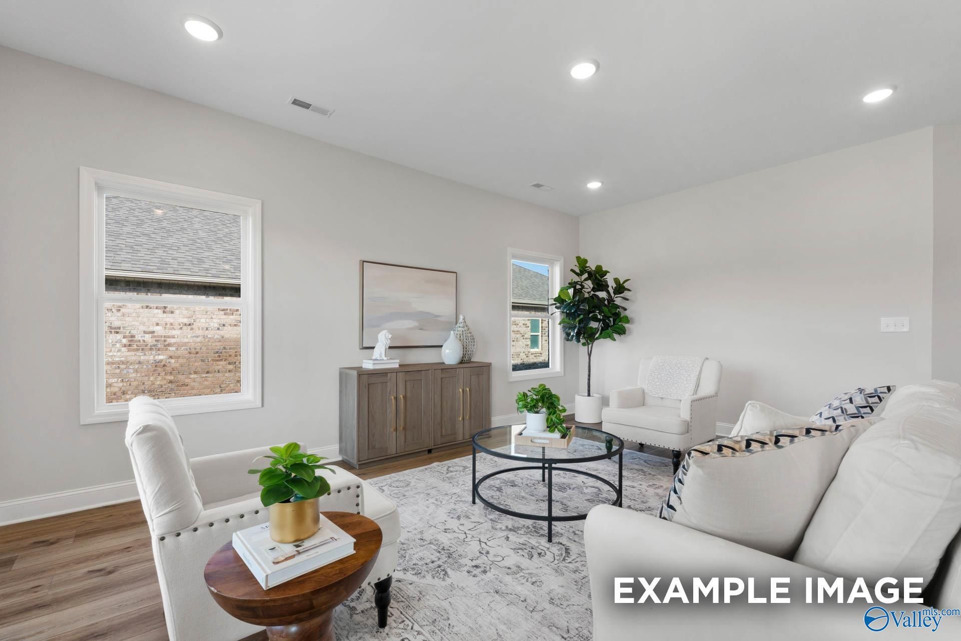 Bright, open living room with neutral decor in The Franklin C floor plan at Heritage Lakes, New Market, Alabama.