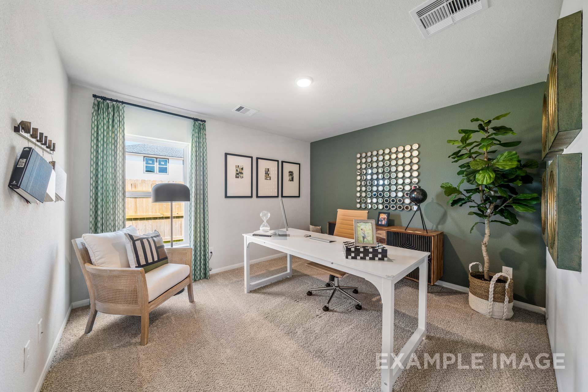 Modern home office in The Acadia A featuring white desk, green accent wall, potted plants, and large window
