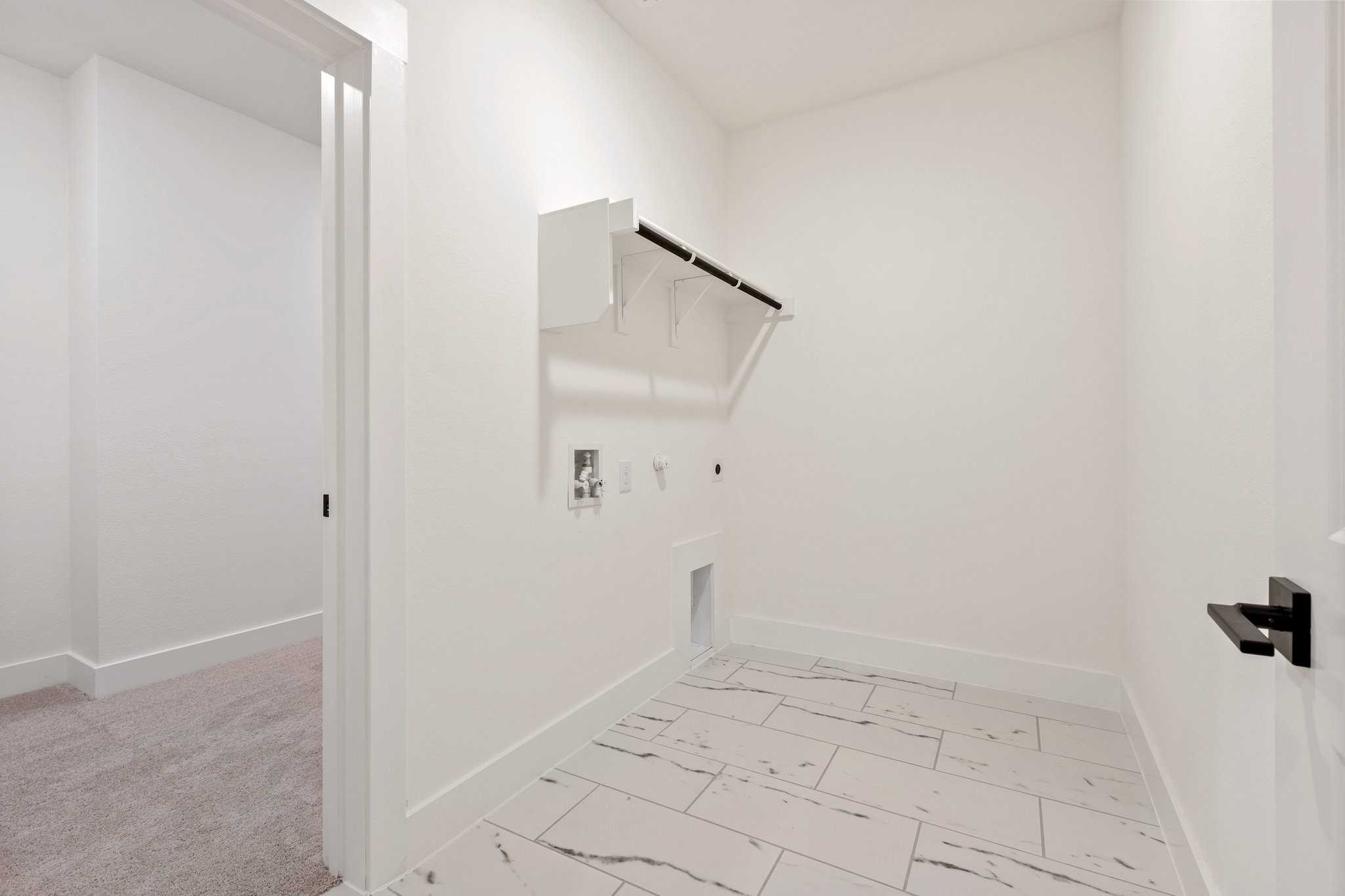 Modern laundry room with white cabinetry, washer/dryer hookups, and tiled floor in Davidson Homes The Rockford C, Josephine, Texas