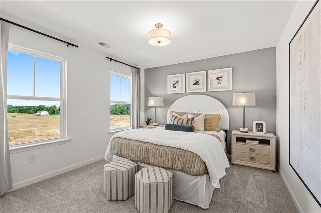 Cozy secondary bedroom with gray walls, tufted white headboard bed, nightstands, and field-view window in Davidson Homes The Hickory B, Hoschton, GA