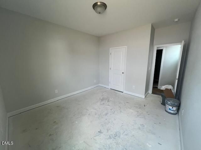 Spacious unfinished bedroom with gray walls, white doors, and bare concrete floor in Davidson Homes The Adalynn B, Lillington, NC