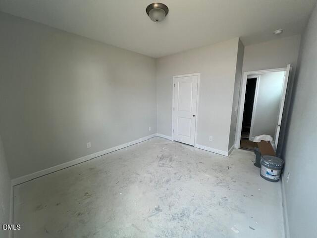 Spacious unfinished bedroom with gray walls, white doors, and bare concrete floor in Davidson Homes The Adalynn B, Lillington, NC