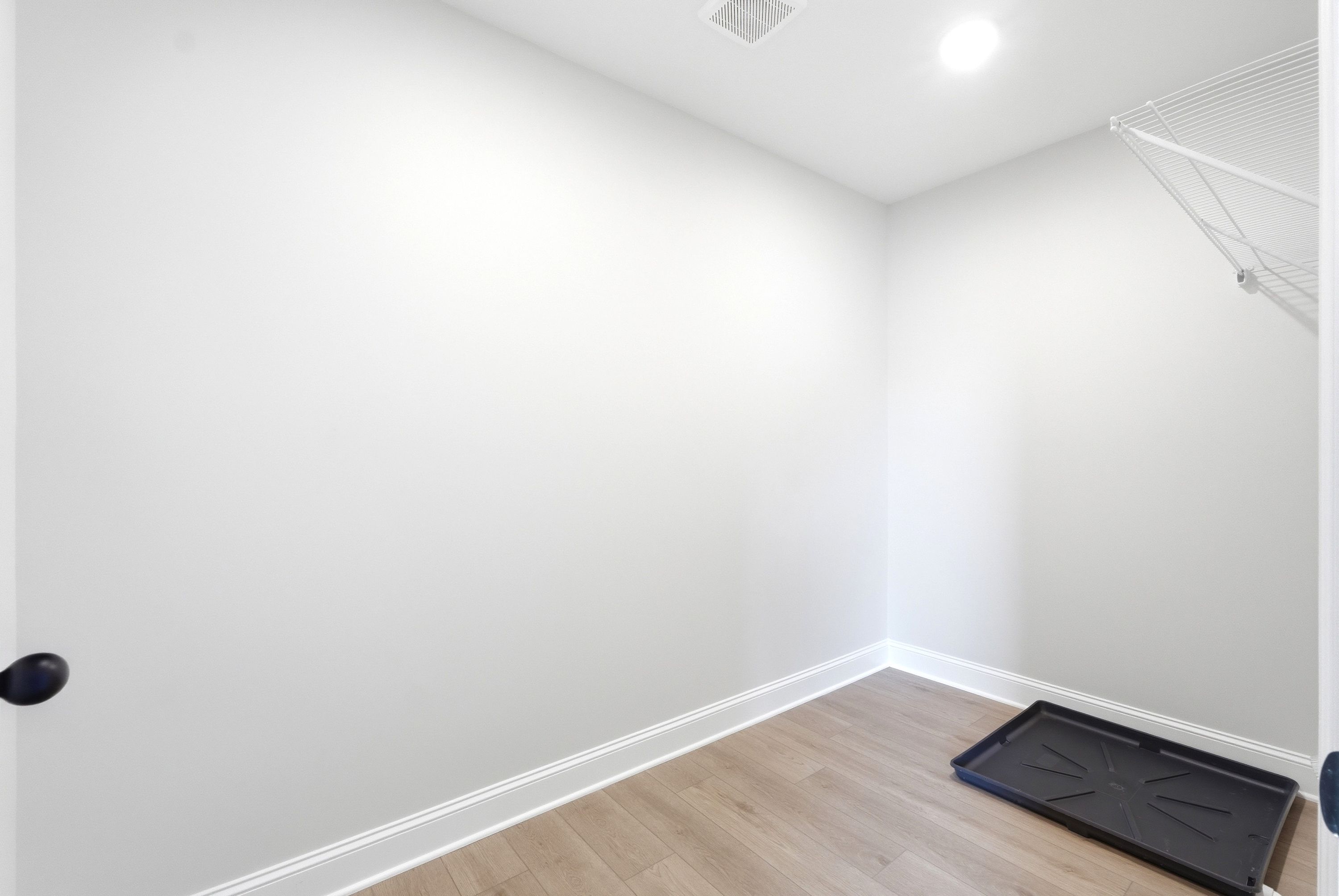 Spacious walk-in closet in The Russell A home design featuring wood-look flooring and built-in wire shelving.