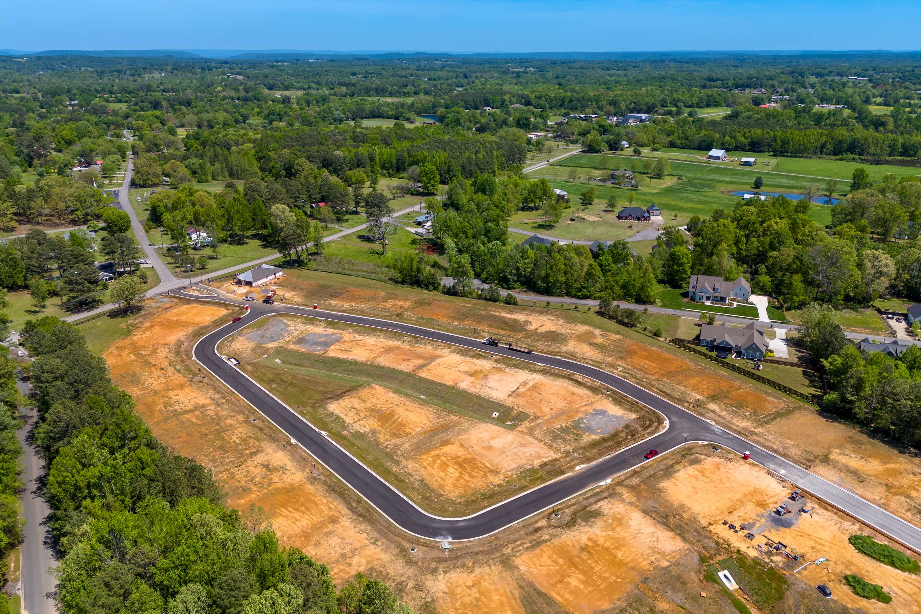 Aerial view of The Highlands neighborhood construction in Arab AL with new roads homesites and surrounding greenery