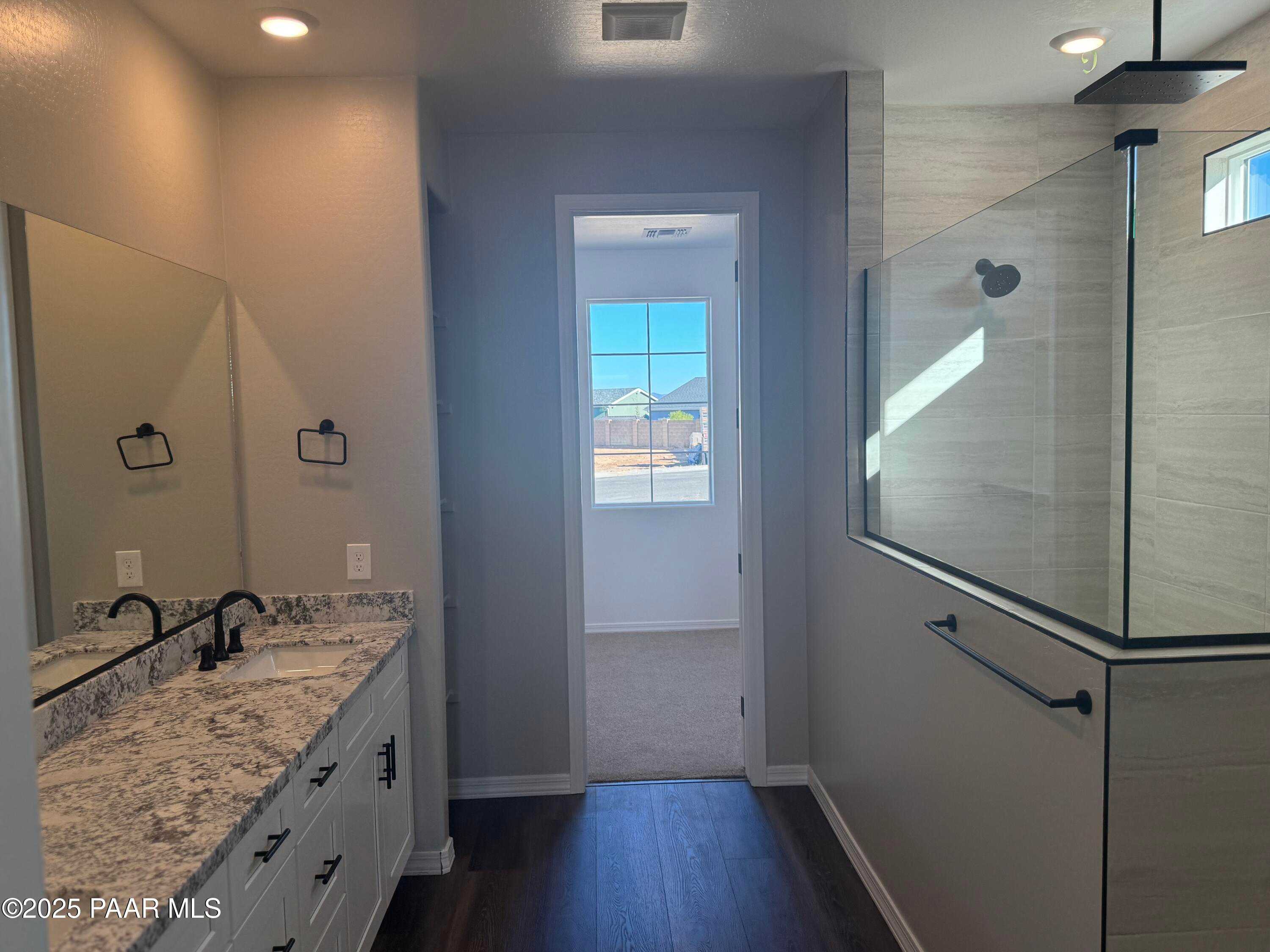 Modern master bathroom featuring double quartz vanity, frameless glass shower, and sunny window in Davidson Homes The Monarch E, Prescott, AZ
