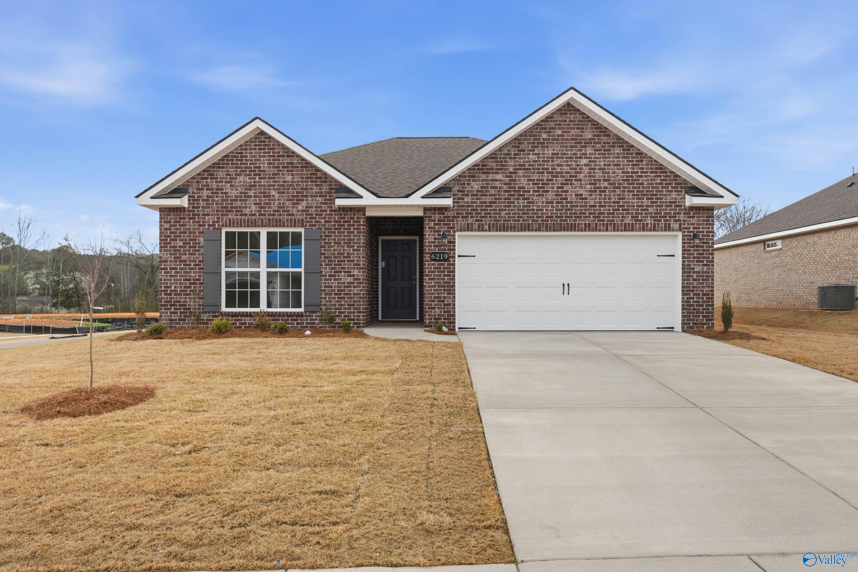 Brick ranch-style home with red brick facade, 2-car garage, and front lawn in Spragins Cove, Huntsville, Alabama by Davidson Homes