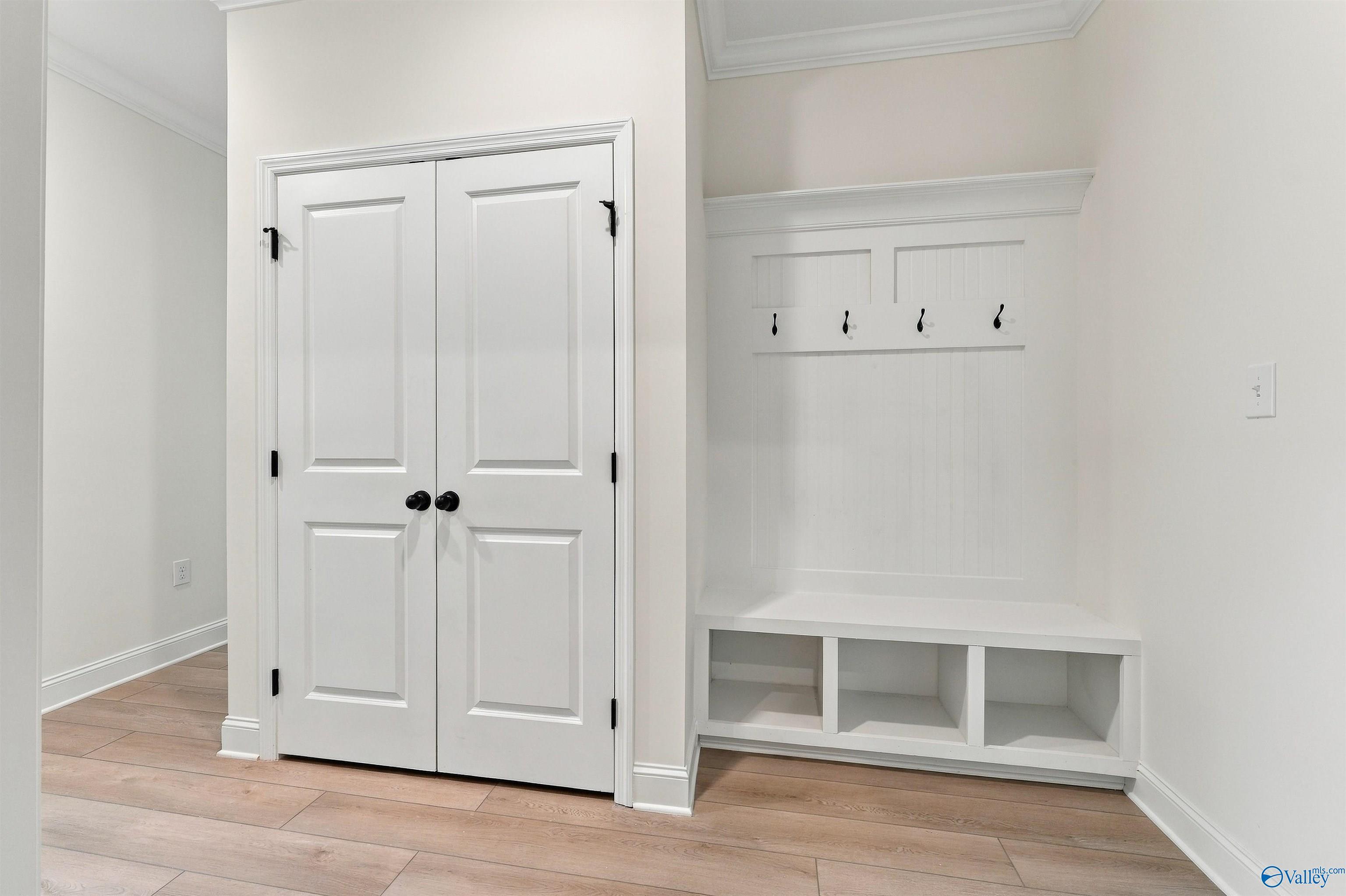 Mudroom with white bench, cubby storage, coat hooks, and double closet doors in Davidson Homes Valencia plan, Huntsville, AL