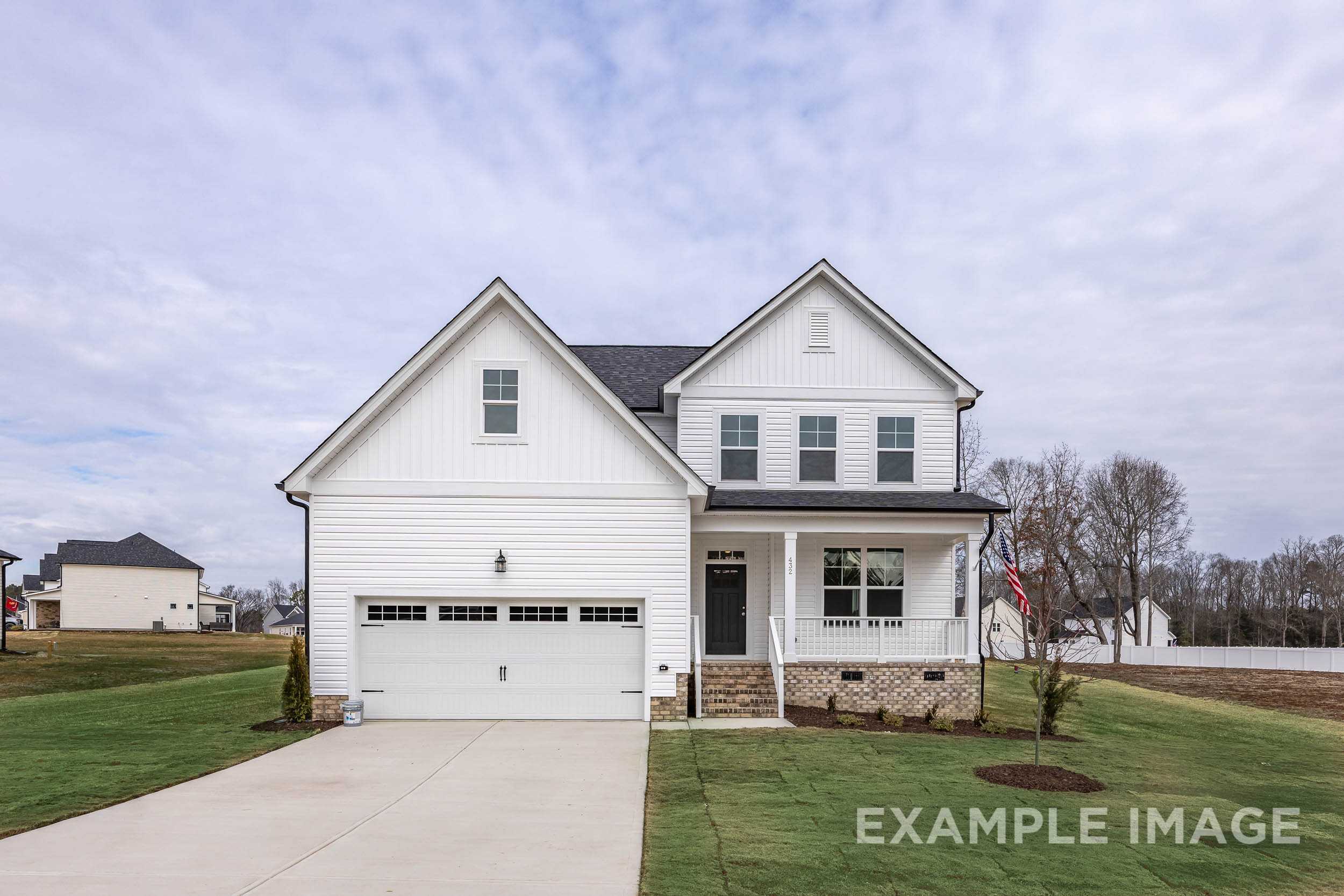 Modern white two-story exterior of The Ash home design by Davidson Homes with two-car garage and covered porch in Lillington NC