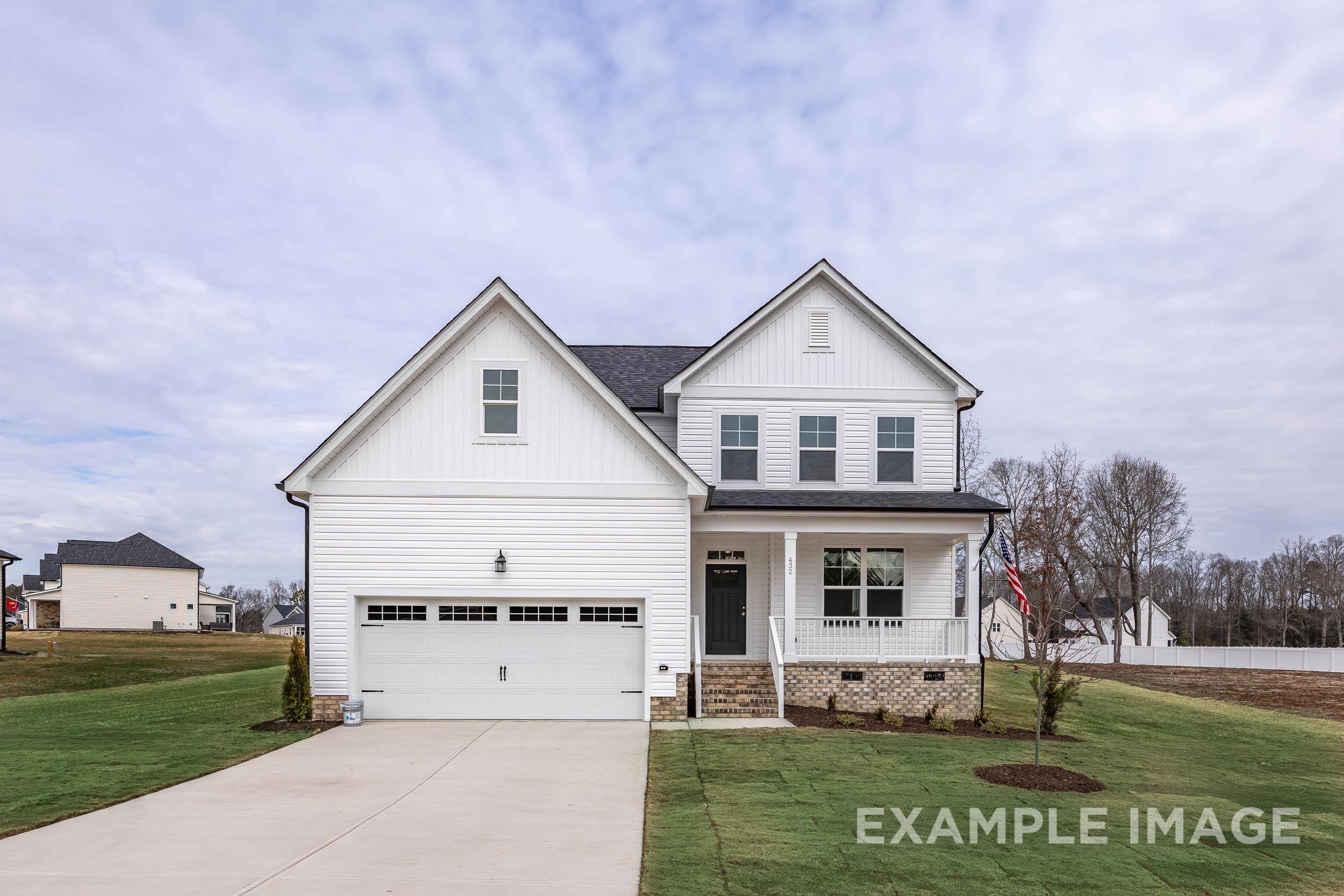 Modern white two-story exterior of The Ash home design by Davidson Homes with two-car garage and covered porch in Lillington NC