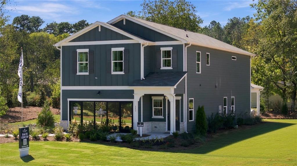 Two-story green Davidson Homes model with covered porch and 2-car garage at Greene Farm sales center in Cartersville, Georgia