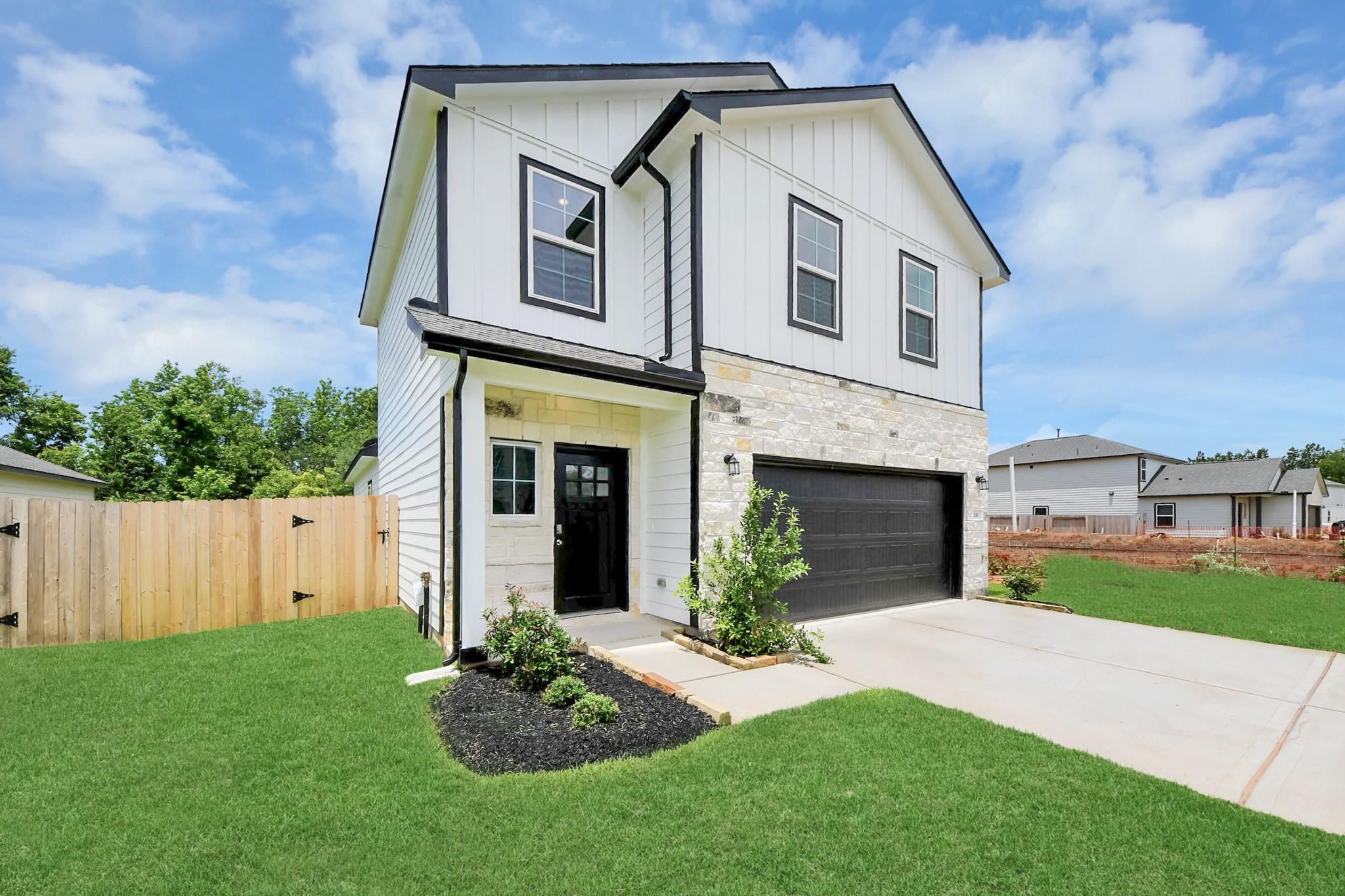 Two-story Blanco E floor plan by Davidson Homes with stone exterior and 2-car garage in Caney Creek Place, Conroe, Texas.