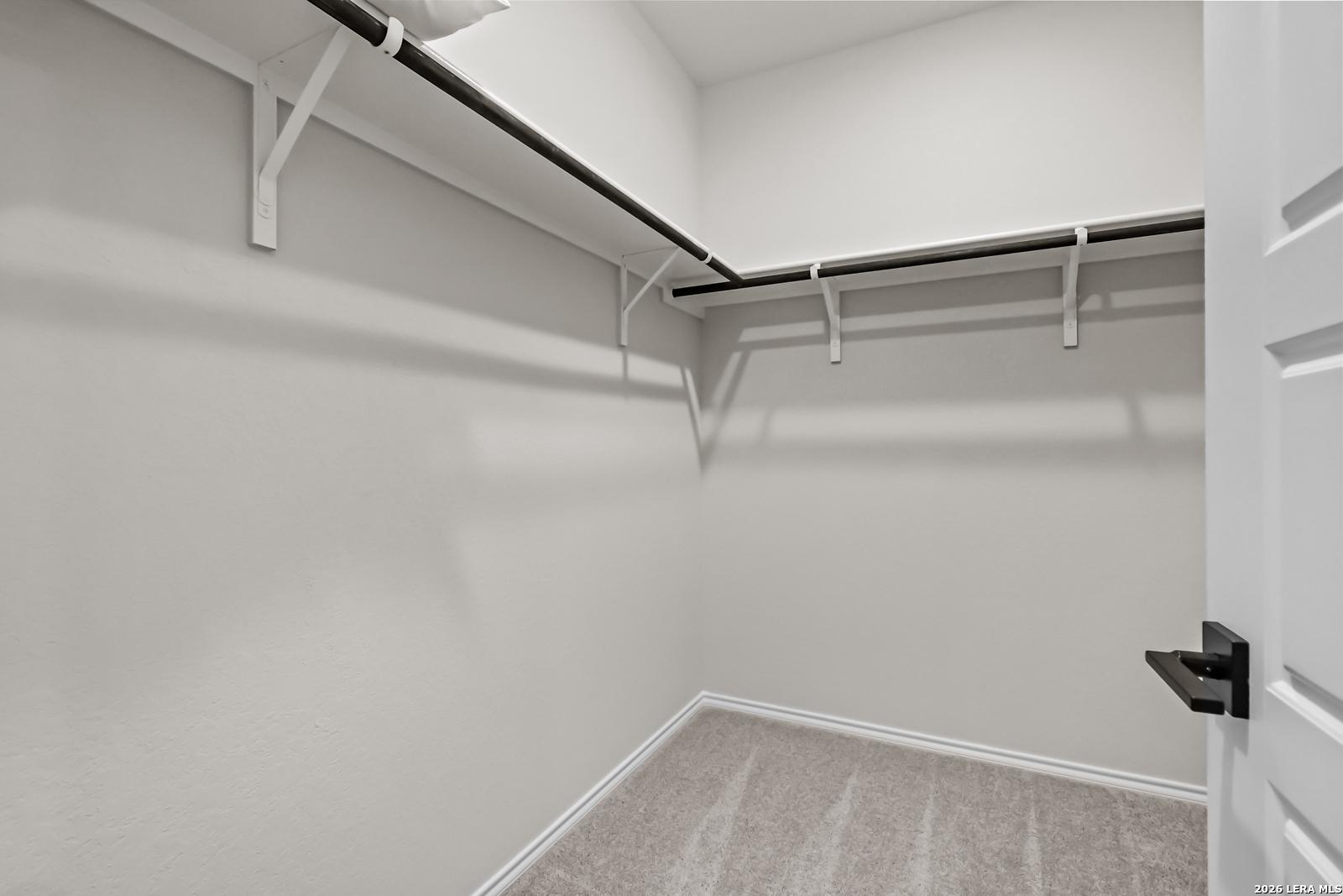 Spacious walk-in closet with built-in shelving in The Douglas C floor plan by Davidson Homes in Hannah Heights, Seguin, TX.