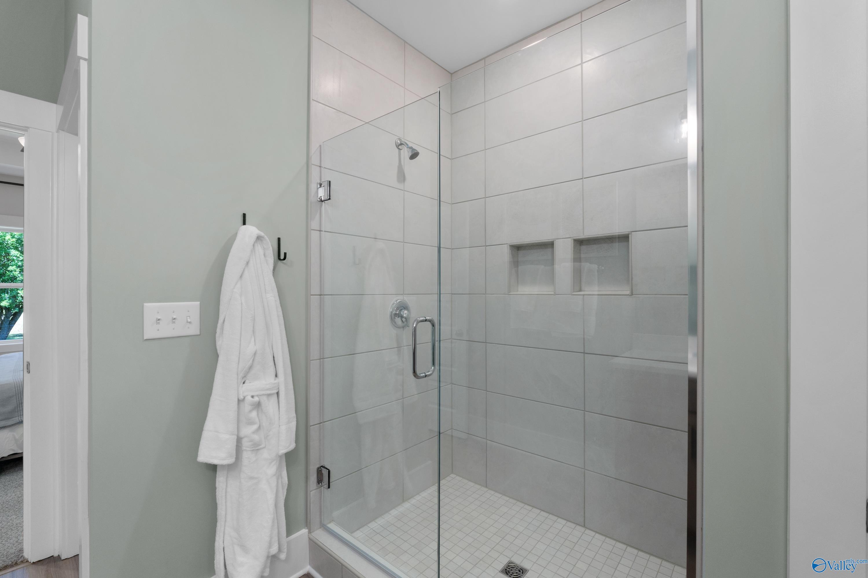 Modern walk-in shower with glass door and tile walls in The Franklin floor plan home by Davidson Homes in Decatur, Alabama.