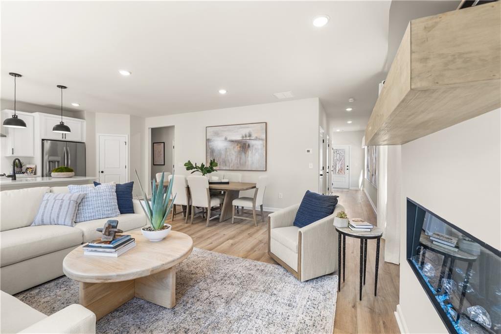 Modern open-concept living room with linear gas fireplace, white sofa, dining table in Davidson Homes The Burton C, Canton, GA